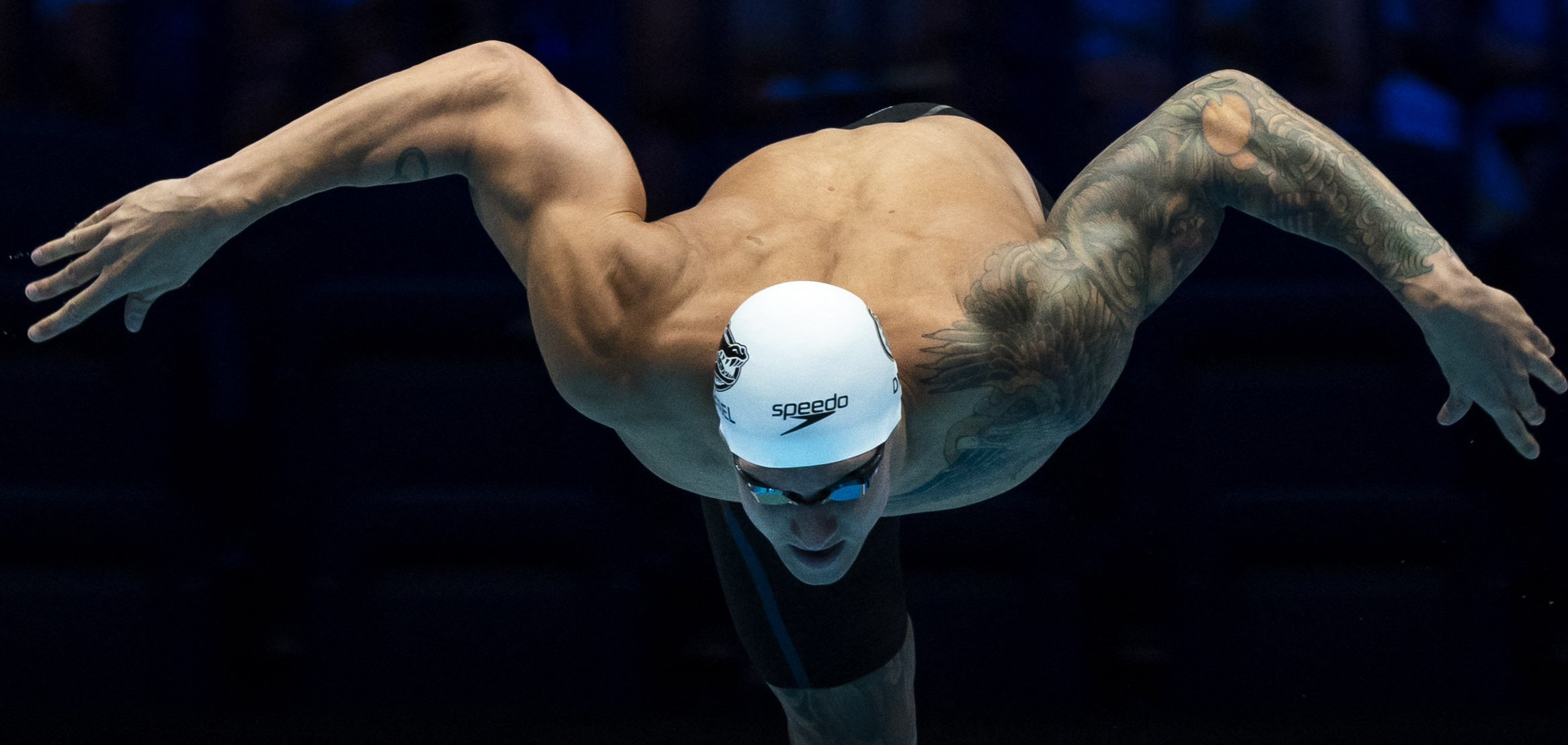 Swimmer leaps off starting block.