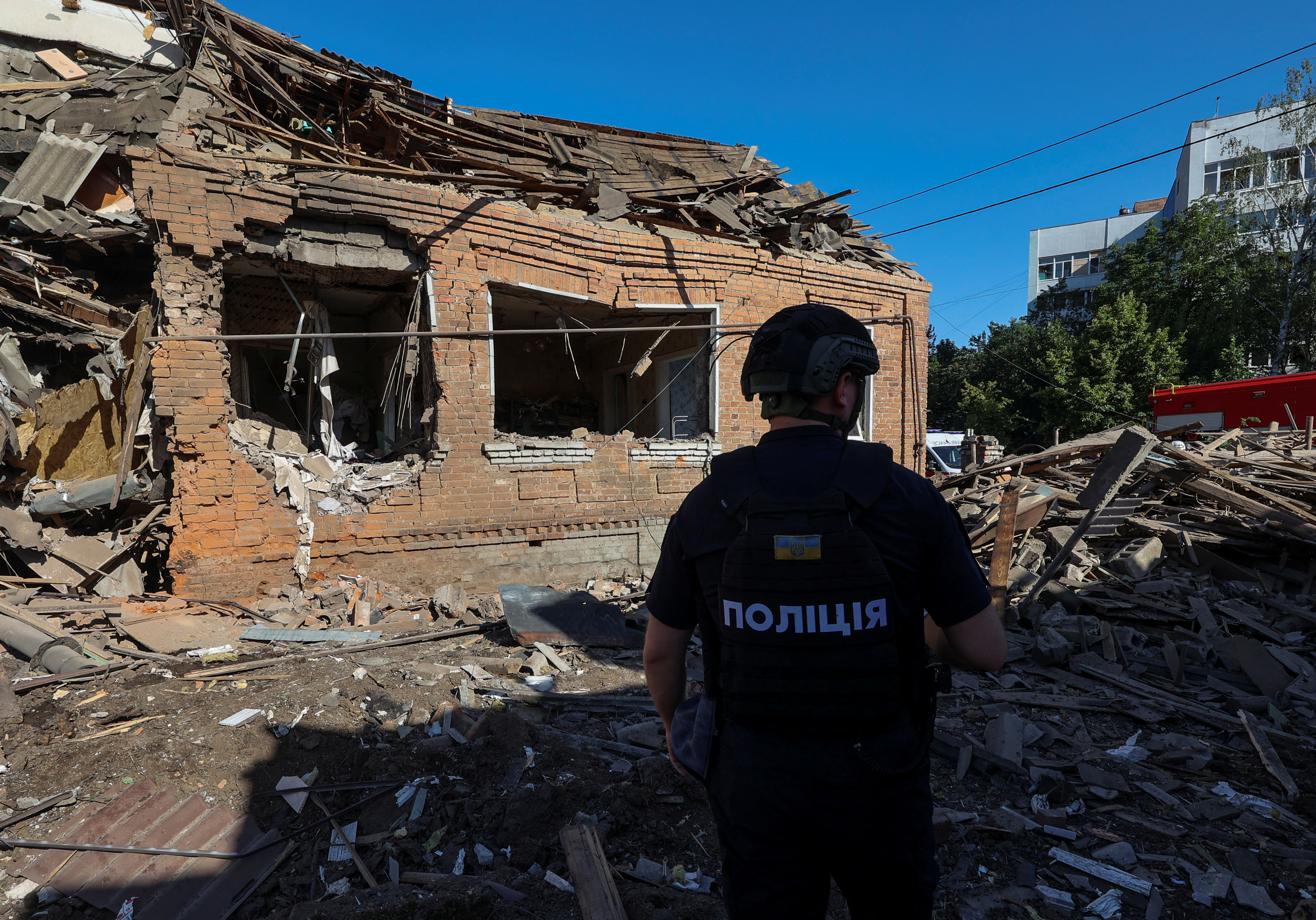 A police officer inspects the site where a residential building was heavily damaged by a Russian air strike, amid Russia's attack on Ukraine, in Kharkiv, Ukraine July 3, 2024. REUTERS/Vyacheslav Madiyevskyy