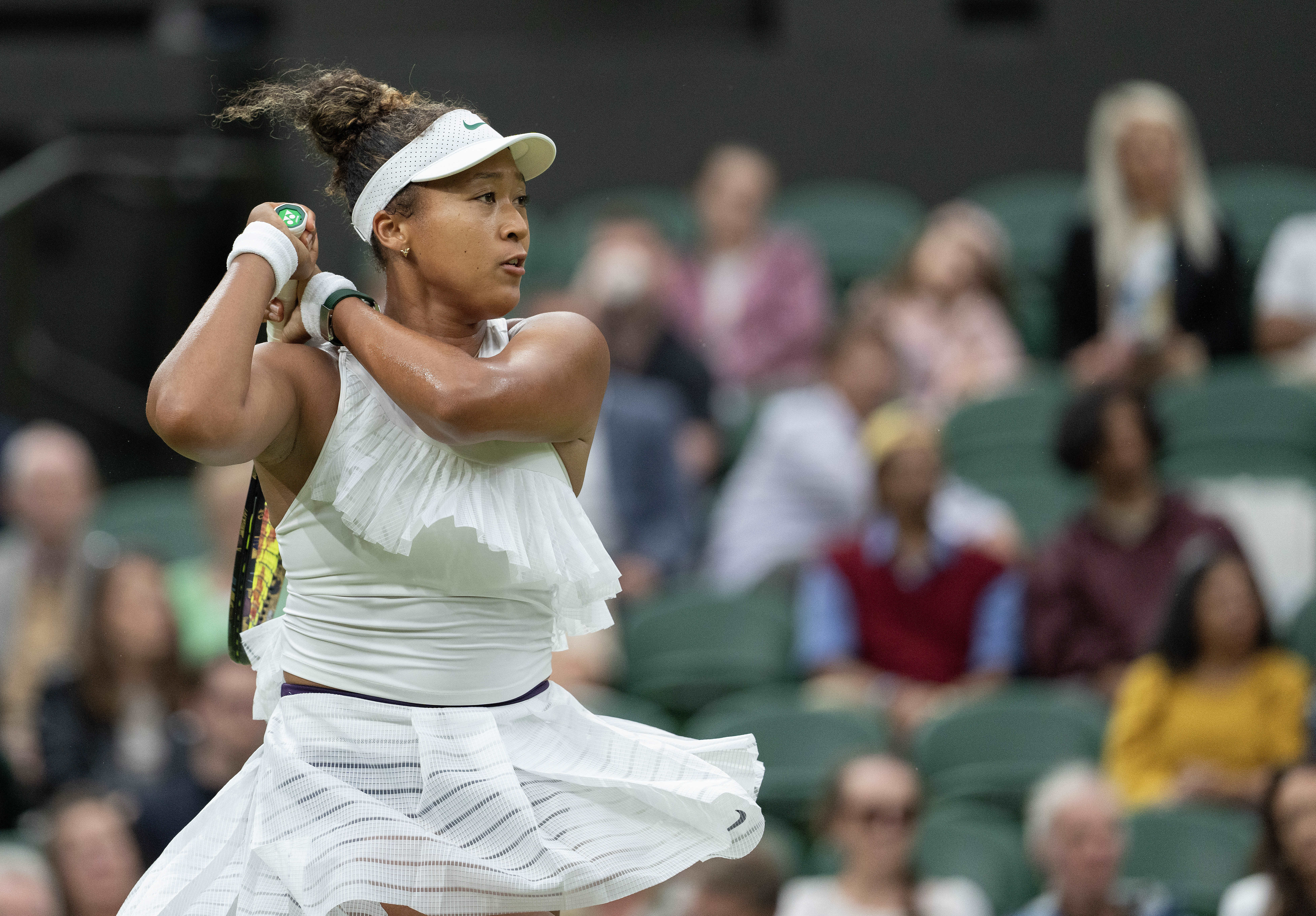 Tennis player strikes ball.