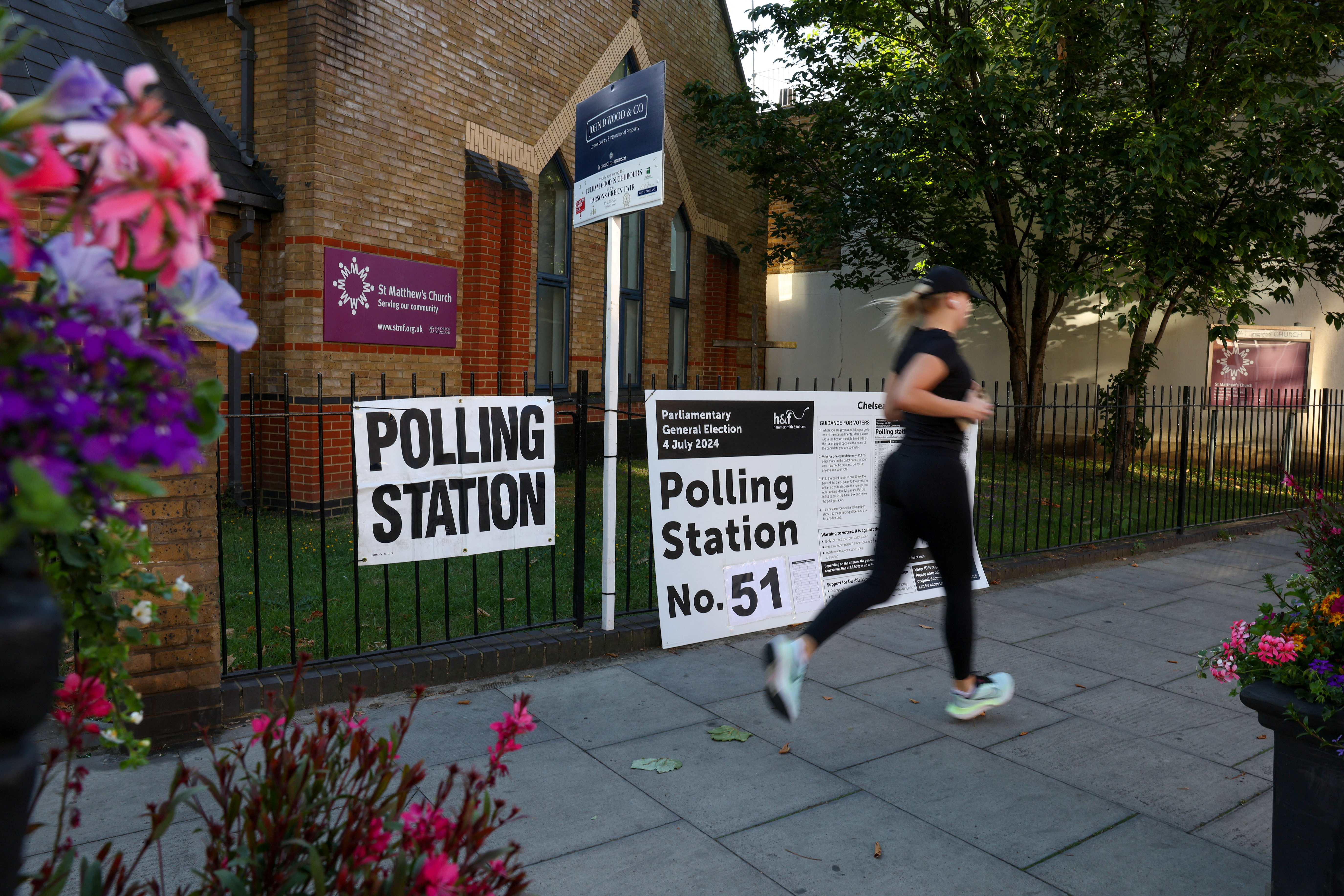 A person runs past a polling station shortly before the polls open and voting begins in the UK general election in London, Britain