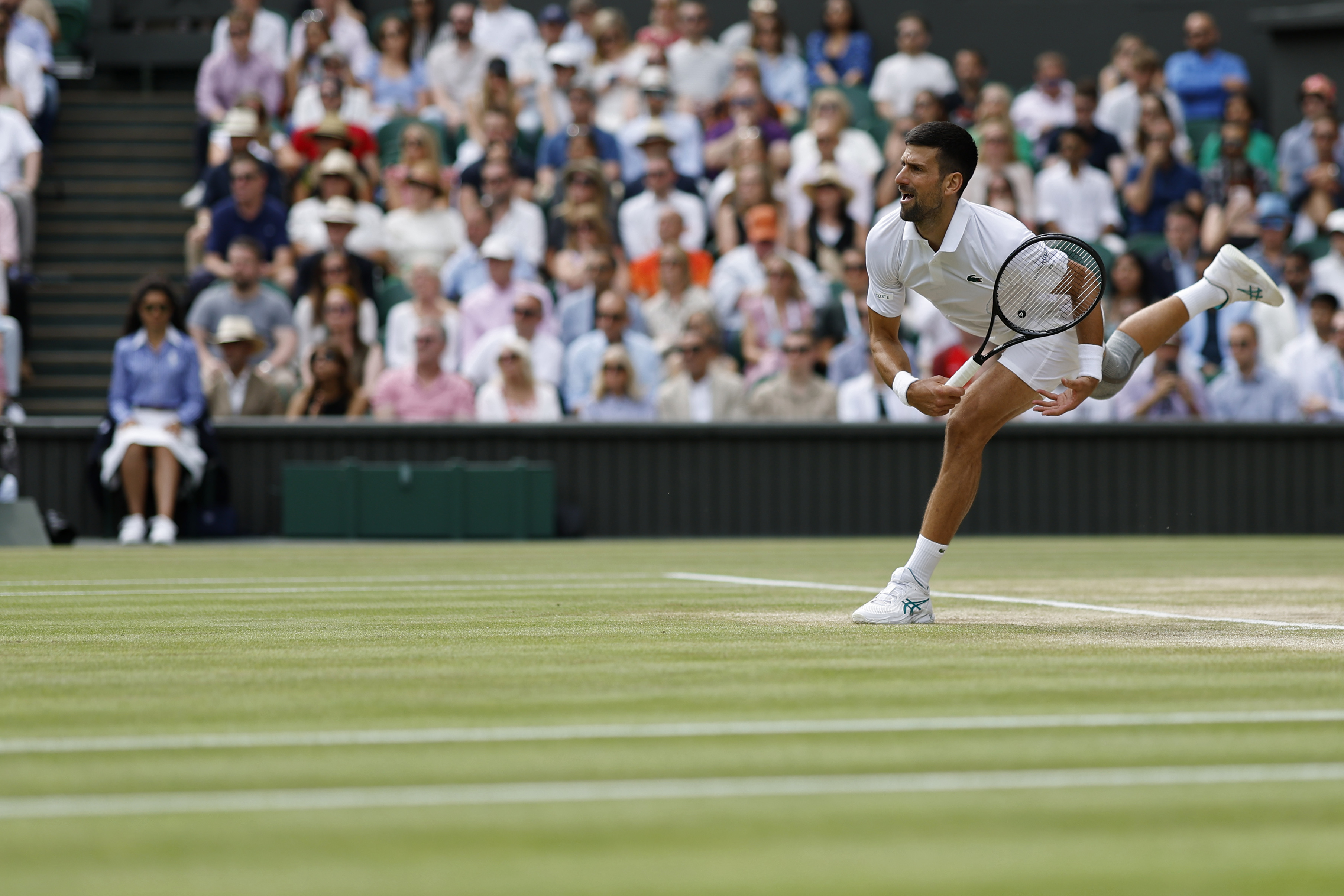 Jul 14, 2024; London, United Kingdom; Novak Djokovic (SRB) serves against Carlos Alcaraz (ESP)(not pictured) in the gentlemen's singles final of The Championships Wimbledon 2024 at The All England Lawn Tennis and Croquet Club. Mandatory Credit: Geoff Burke-USA TODAY Sports