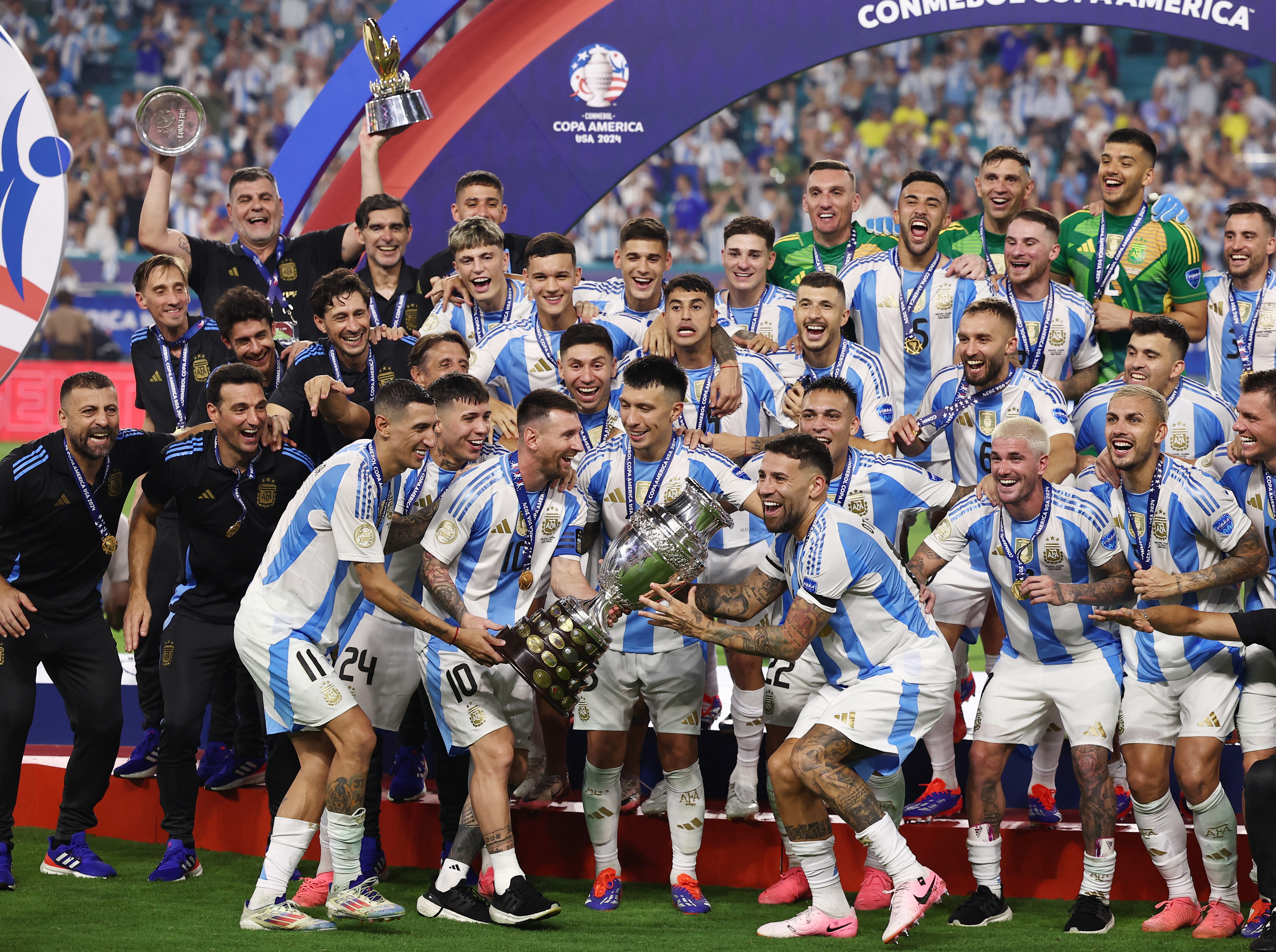 Argentina's Lionel Messi lifts the trophy as he celebrates with teammates after winning Copa America