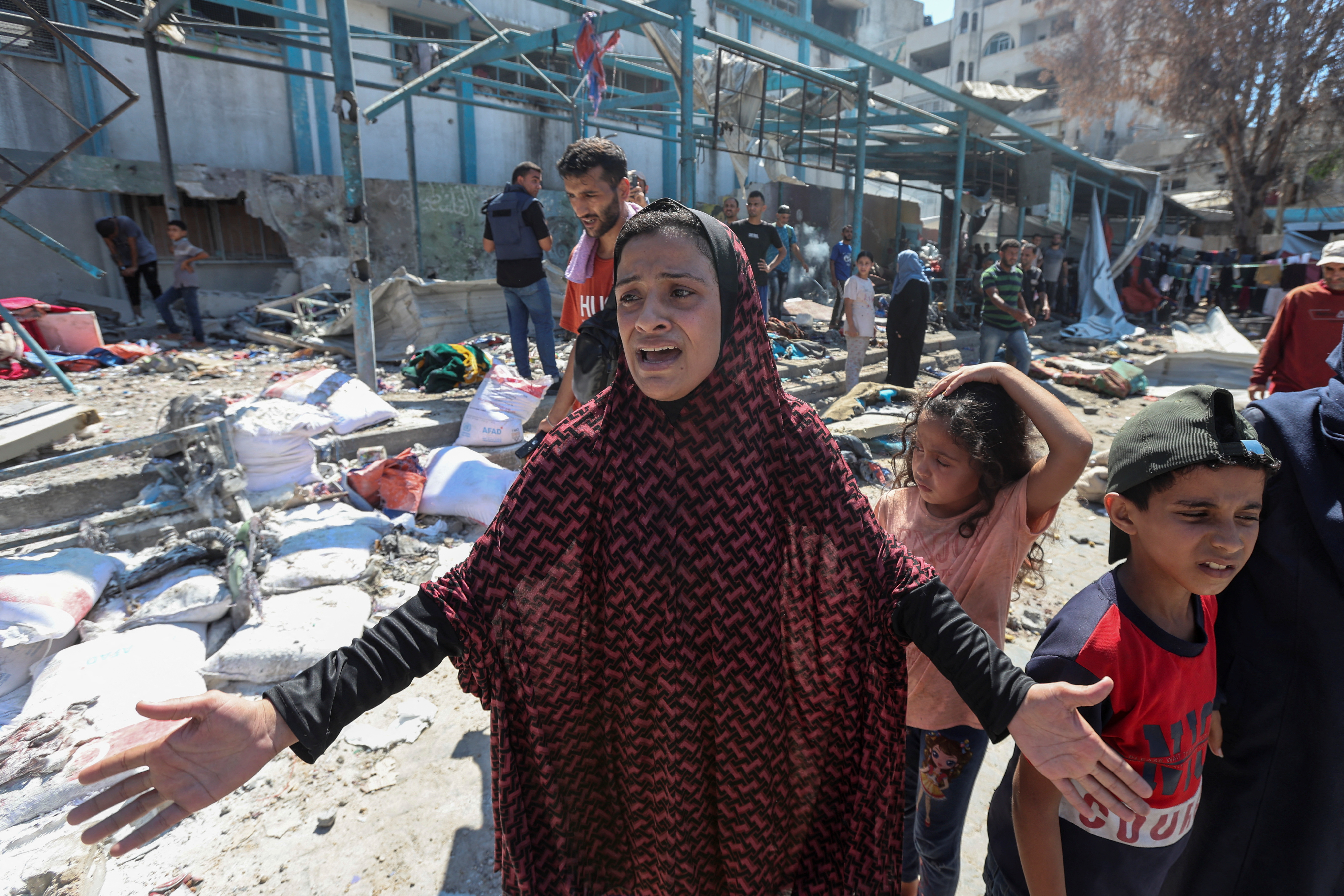 A displaced Palestinian woman reacts at a UN school used as a shelter, following an Israeli strike, amid Israel-Hamas conflict, in Nuseirat in the central Gaza Strip July 16, 2024. [Ramadan Abed/Reuters]