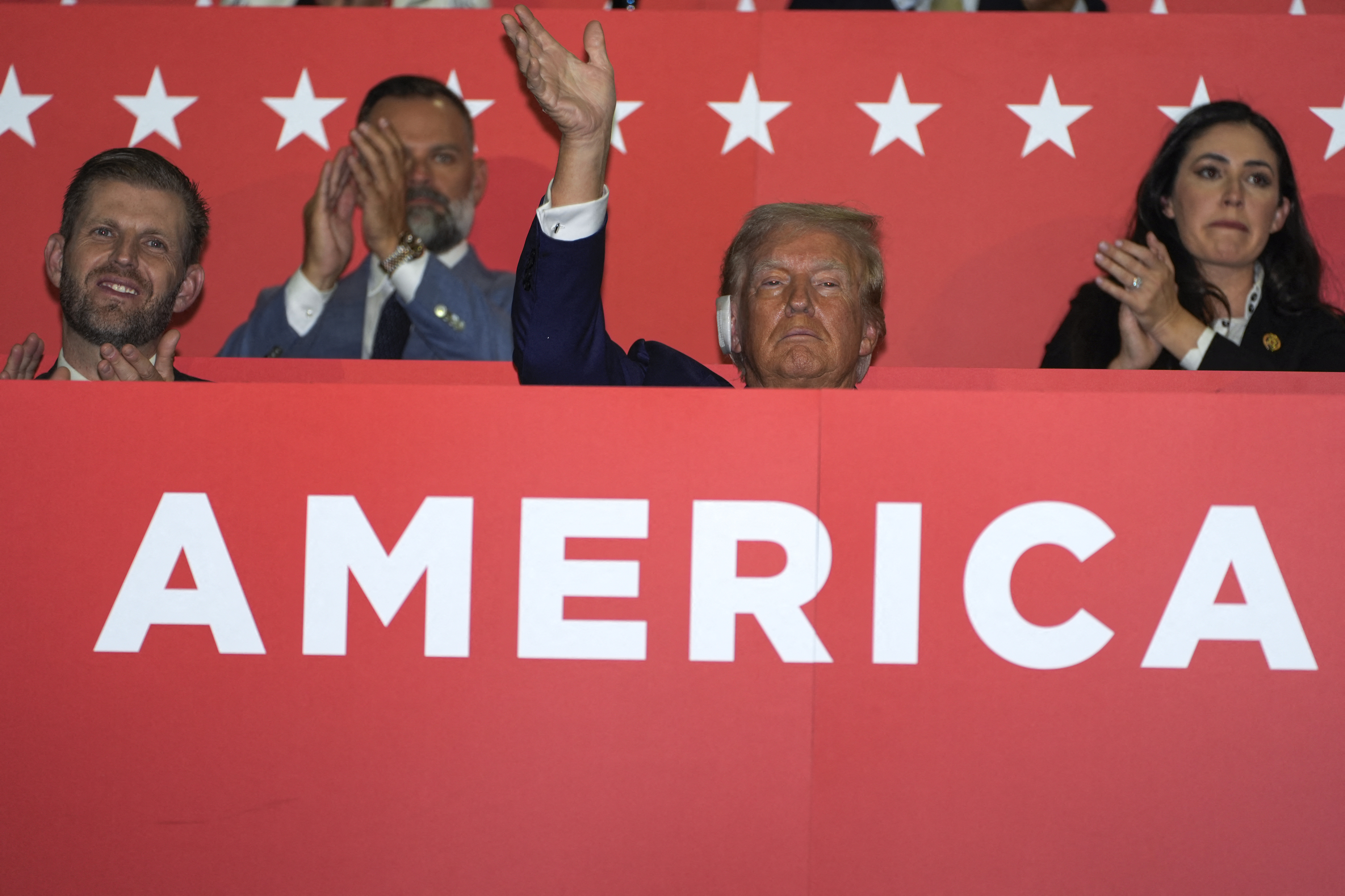 Trump waves from the audience.