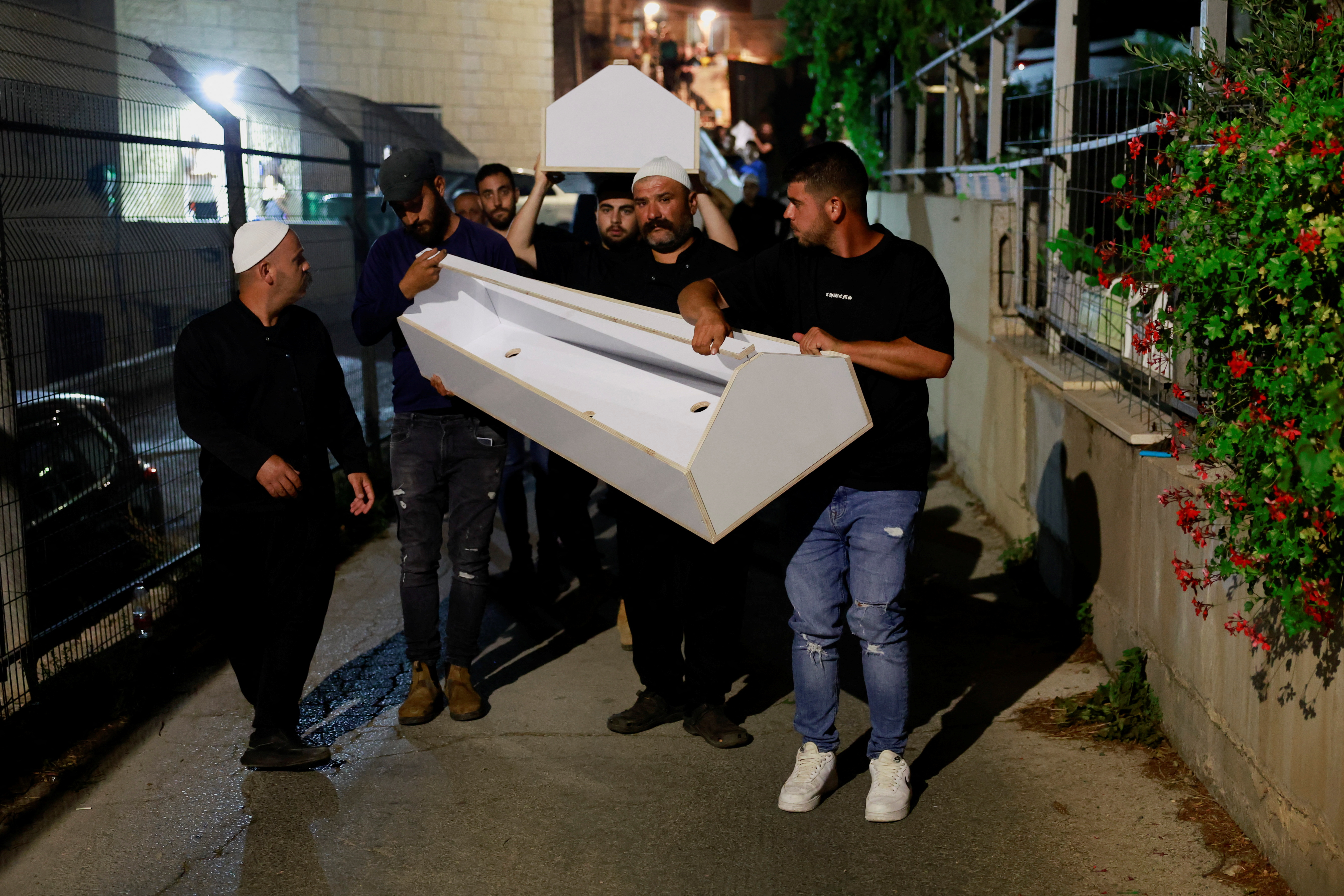 Empty coffins are carried as Israeli officials respond after rockets were launched across Lebanon's border with Israel
