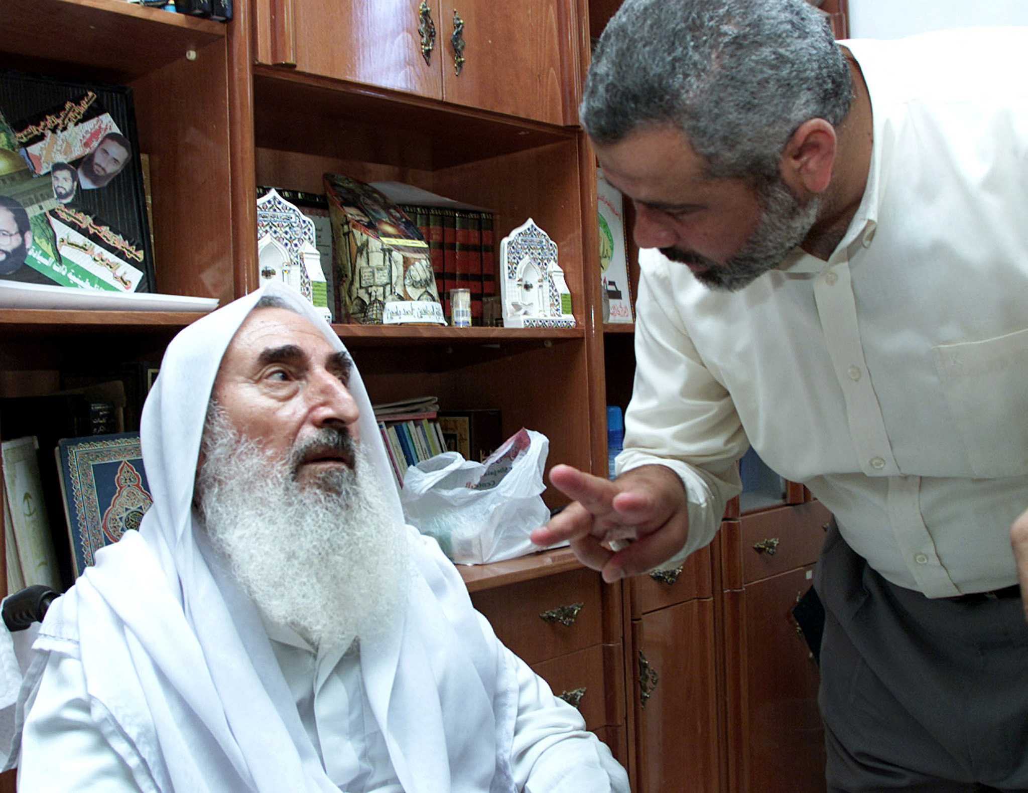 Hamas founder Sheikh Ahmed Yassin talks with his office director Ismail Haniyeh at his home in Gaza Strip June 24, 2002