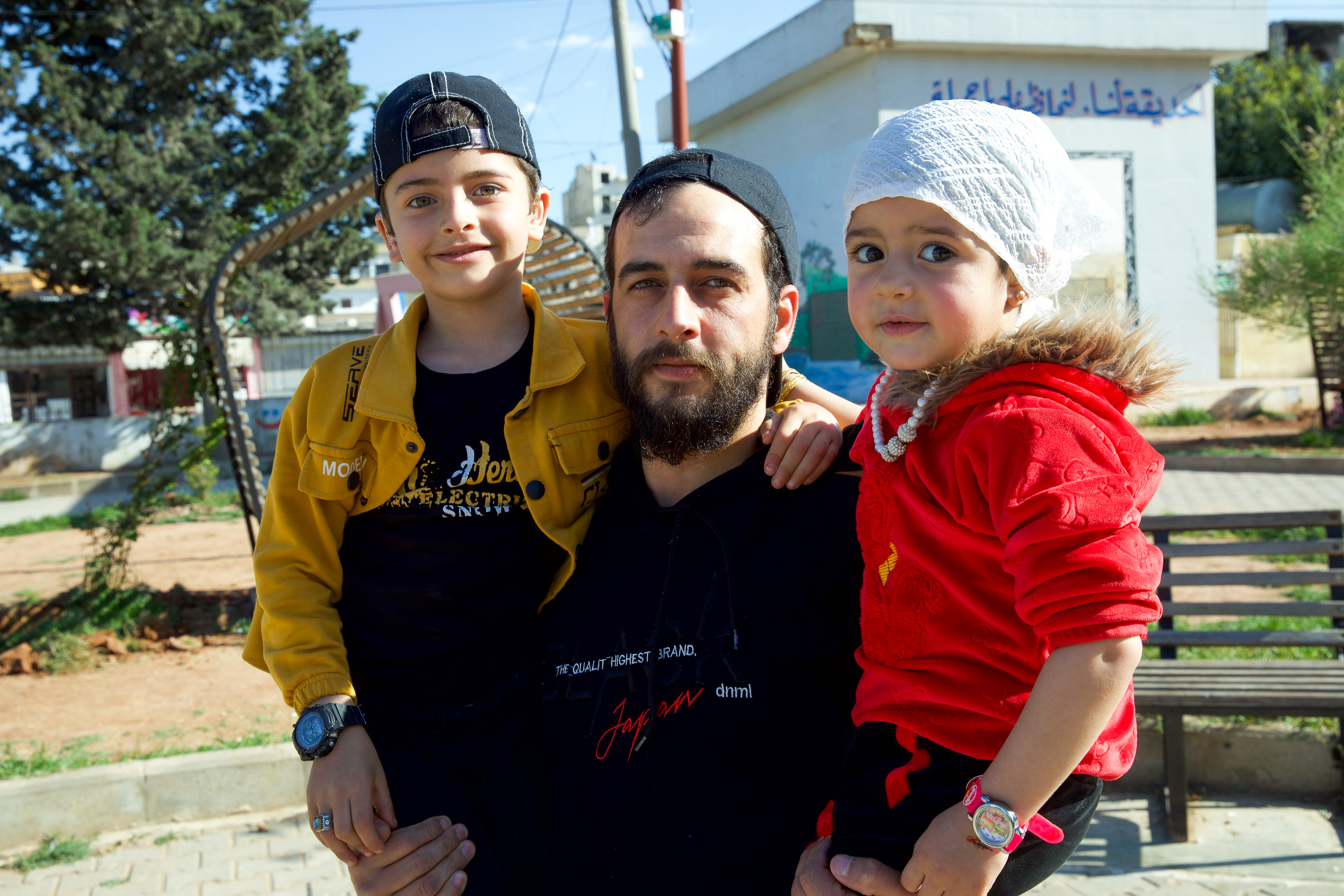 Father holds son and daughter in his arms
