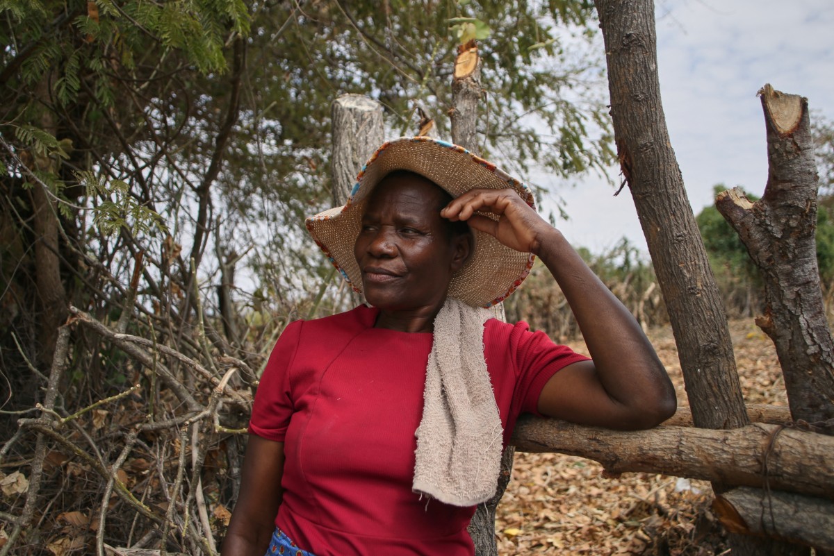 Georgina Kwengwere stands dejected at the entrance to her abandoned vegetable garden,