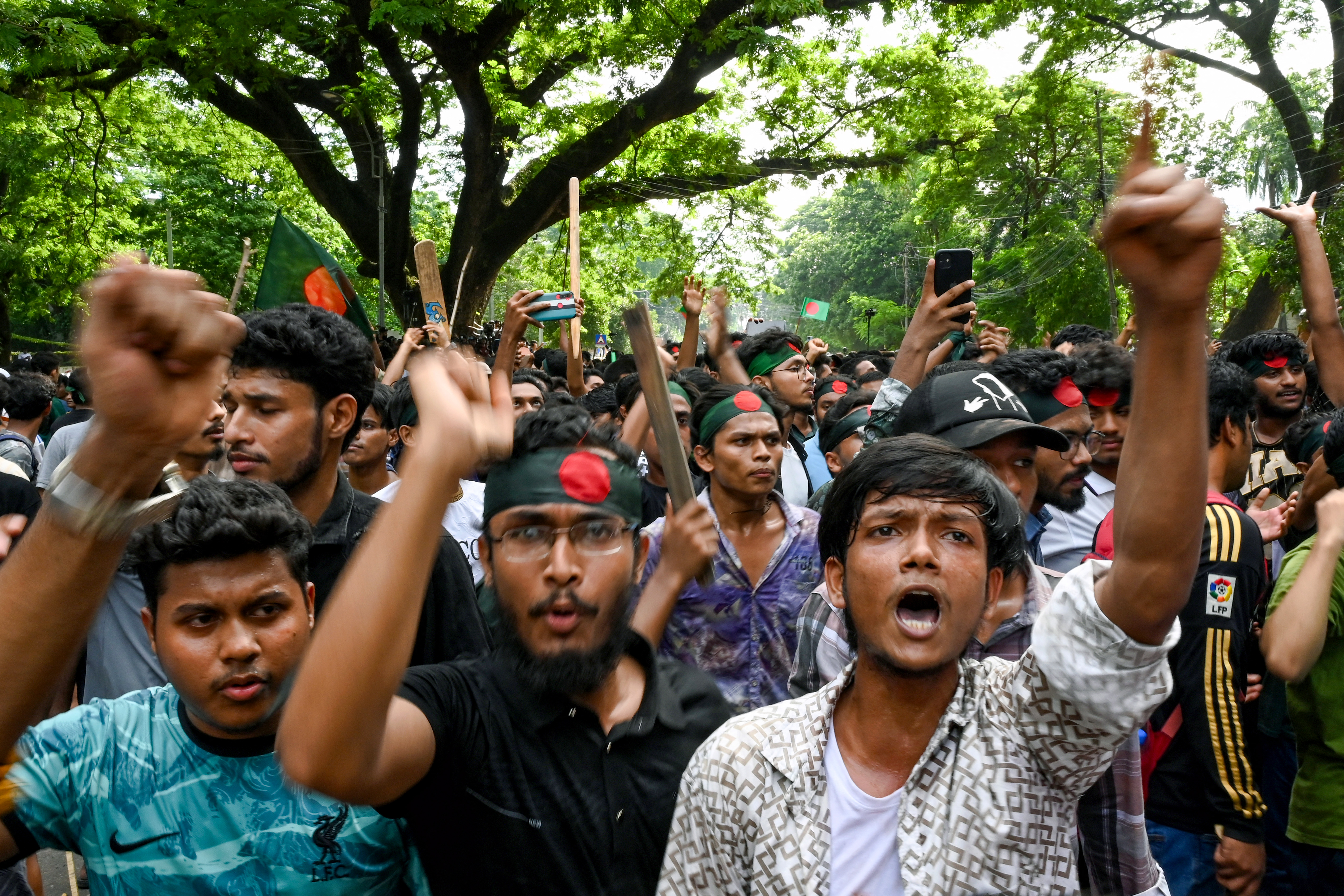 Students wearing headbands with Bangladesh's national flag shout slogans during a protest against quotas in government jobs at Dhaka University