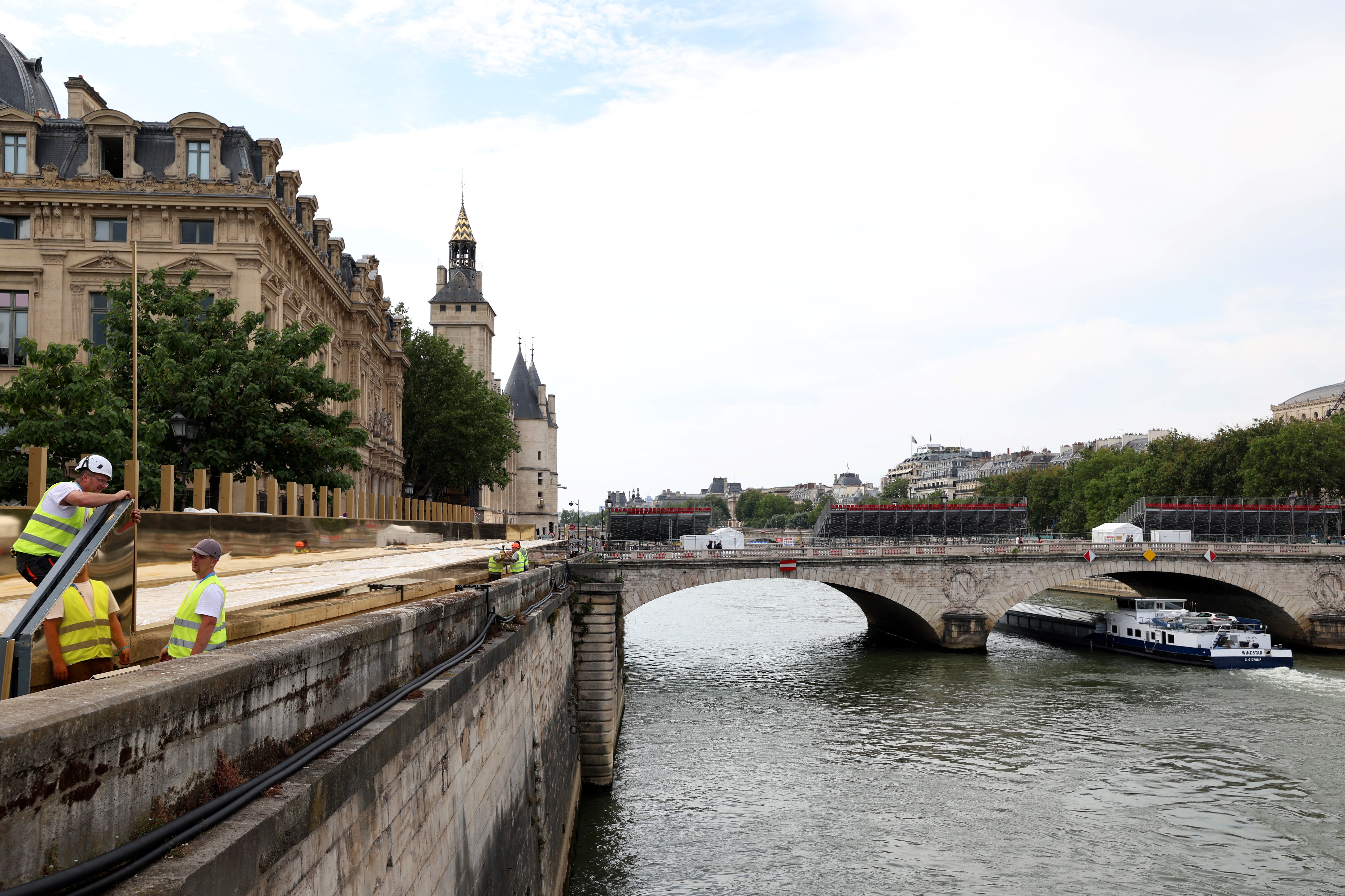 Workers set up stands on the banks of the River Seine in Paris on July 18, 2024, ahead of the opening ceremony of the Paris 2024 Olympic Games. (Photo by EMMANUEL DUNAND / AFP)