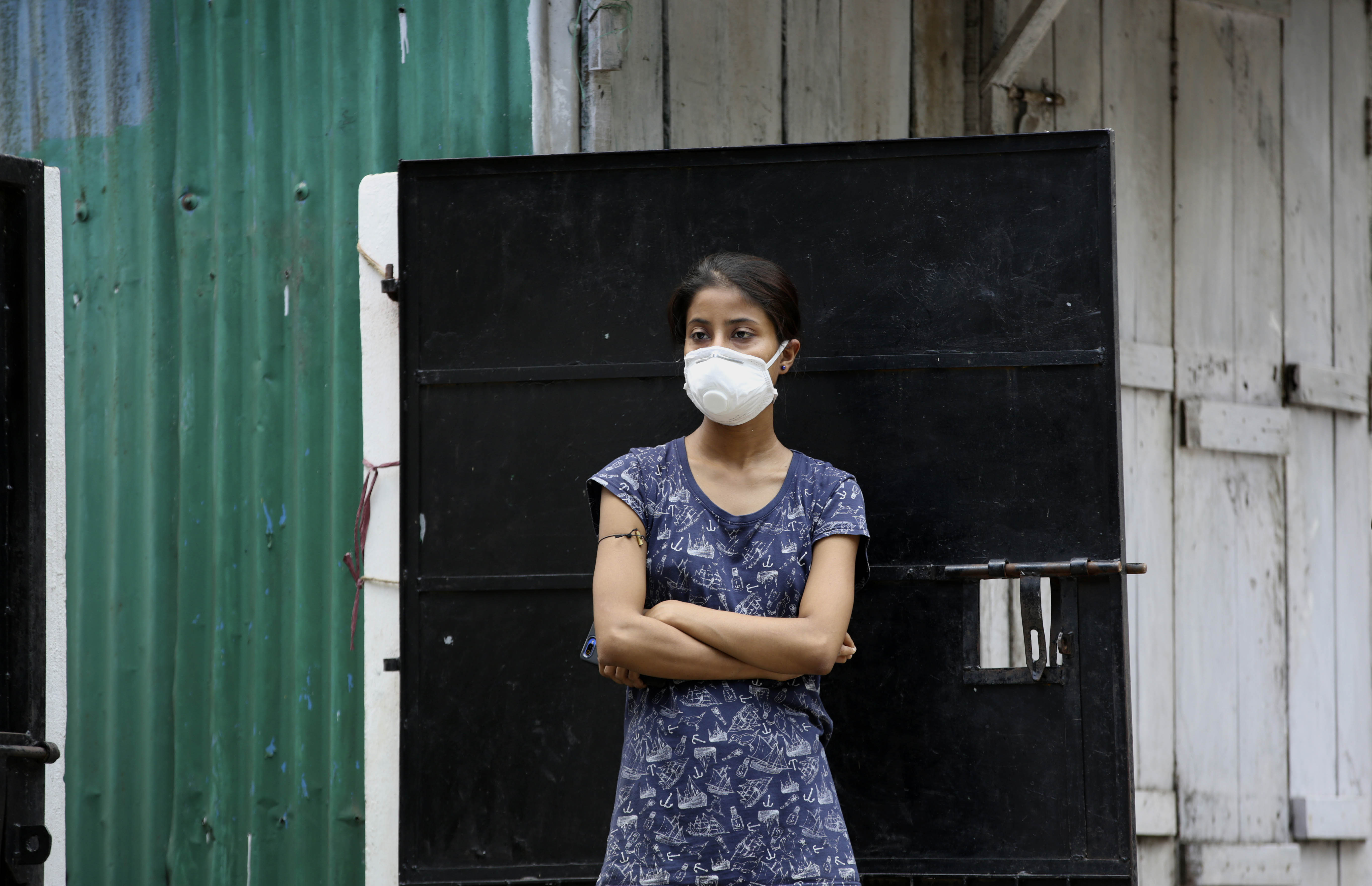 A woman watches health workers pick up relative who has been diagnosed as COVID-19 in Gauhati, India, Saturday, July 4, 2020. India's number of coronavirus cases passed 600,000 on Thursday with the nation's infection curve rising and its testing capacity being increased. More than 60% of the cases are in the worst-hit Maharashtra state, Tamil Nadu state, and the capital territory of New Delhi. (AP Photo/Anupam Nath)