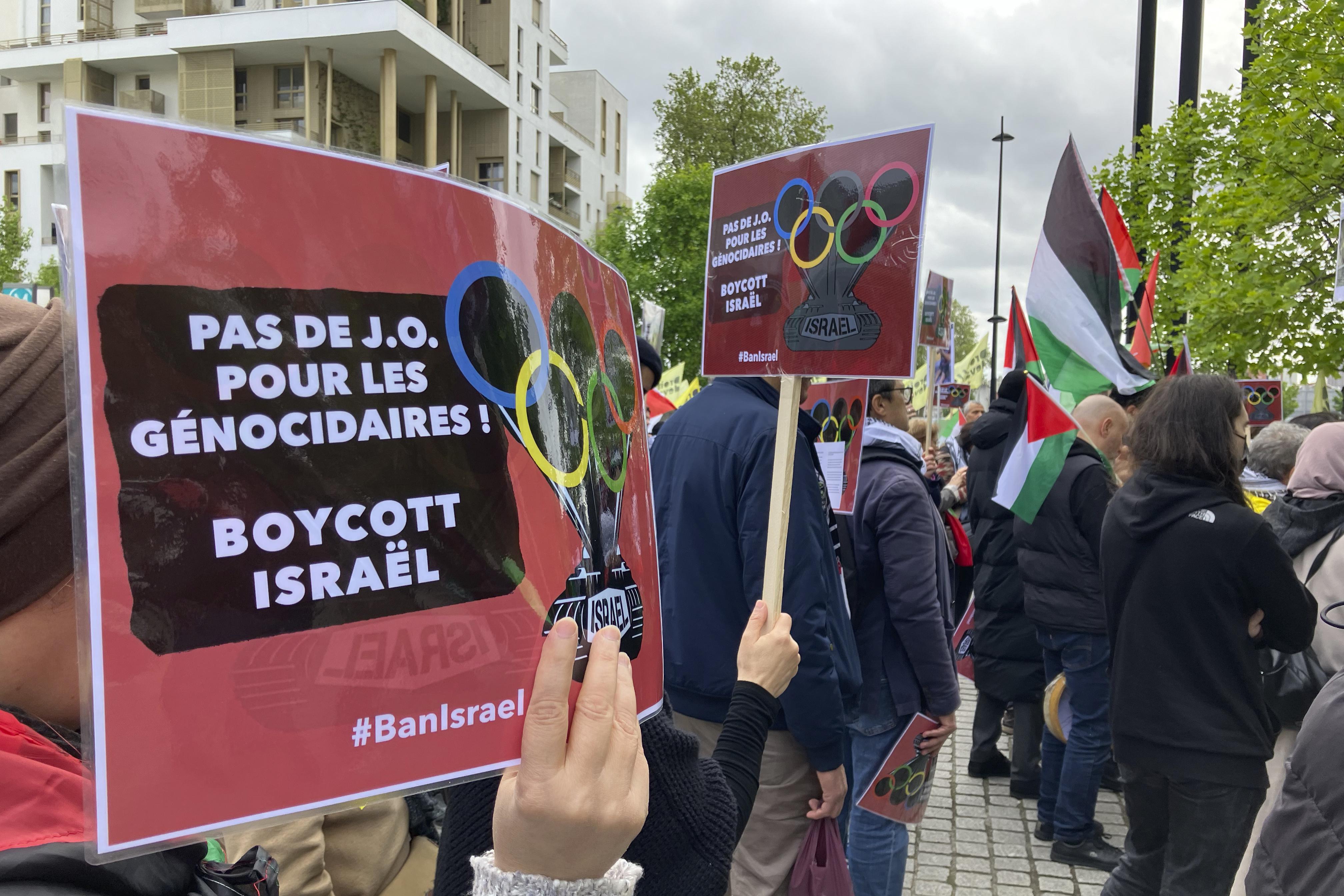 A demonstrator demanding the boycott of Israel during Olympic Games demonstrates with a poster reading "No Games for genocidal, boycott Israel" outside the Paris Olympic organizing committee headquarters