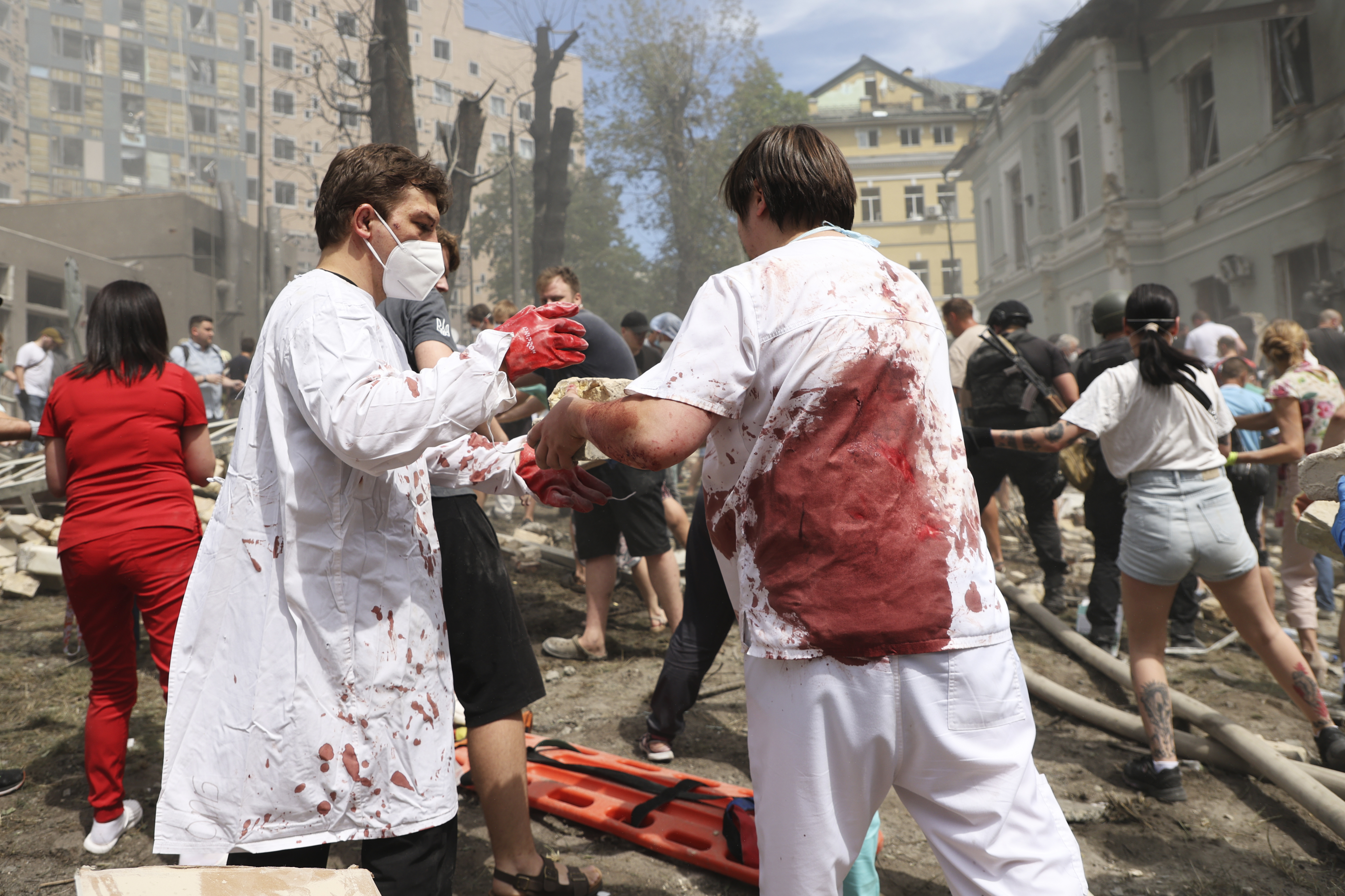 Rescuers, medical staff and volunteers clean up the rubble and search victims after Russian missile hit the country's main children hospital Okhmadit in Kyiv, Ukraine, Monday, July 8, 2024. The daytime barrage targeted five Ukrainian cities with more than 40 missiles of different types hitting apartment buildings and public infrastructure, President Volodymyr Zelenskyy said on social media. (AP Photo/Anton Shtuka)