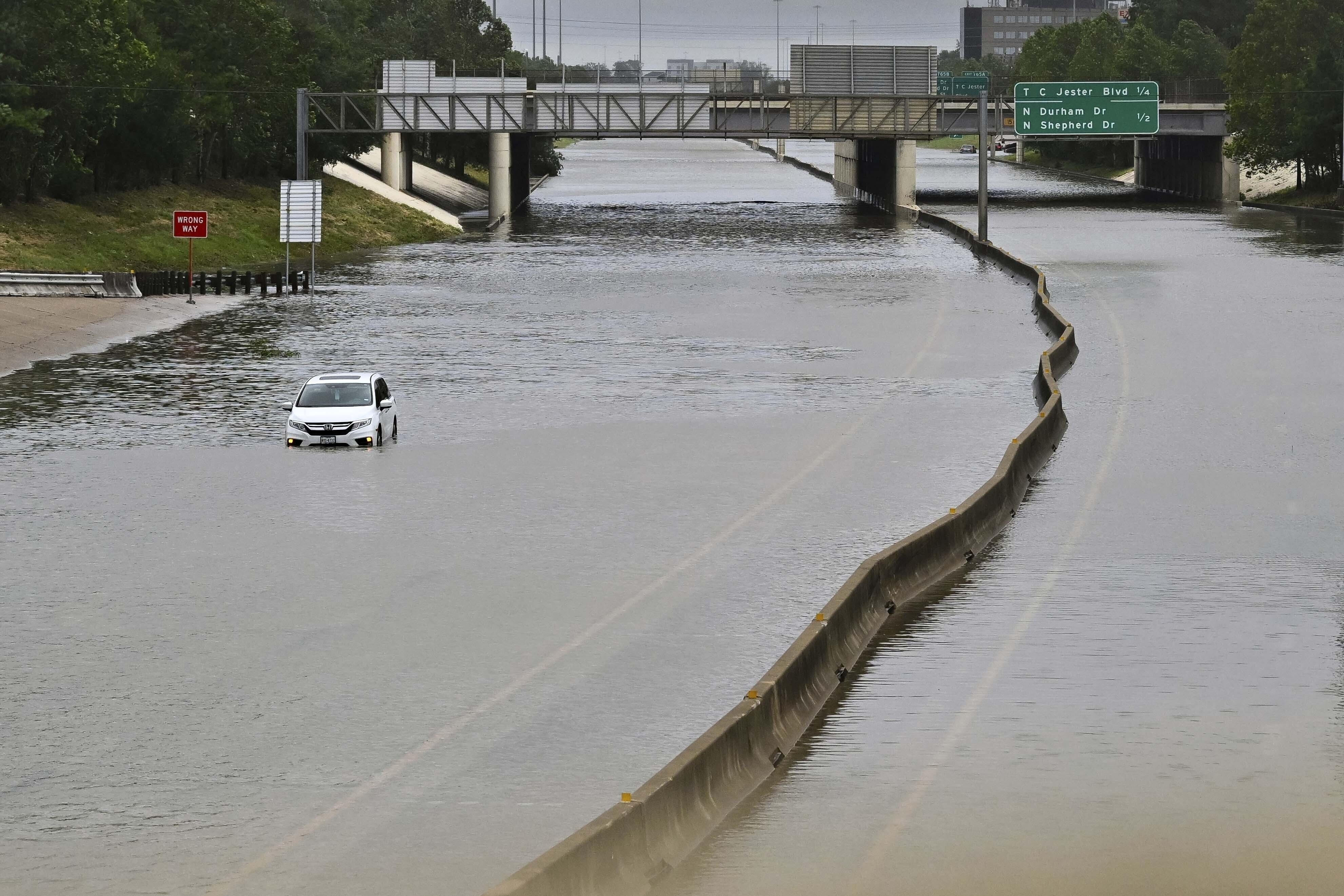 A vehicle is stranded in high waters on a flooded highway in Houston