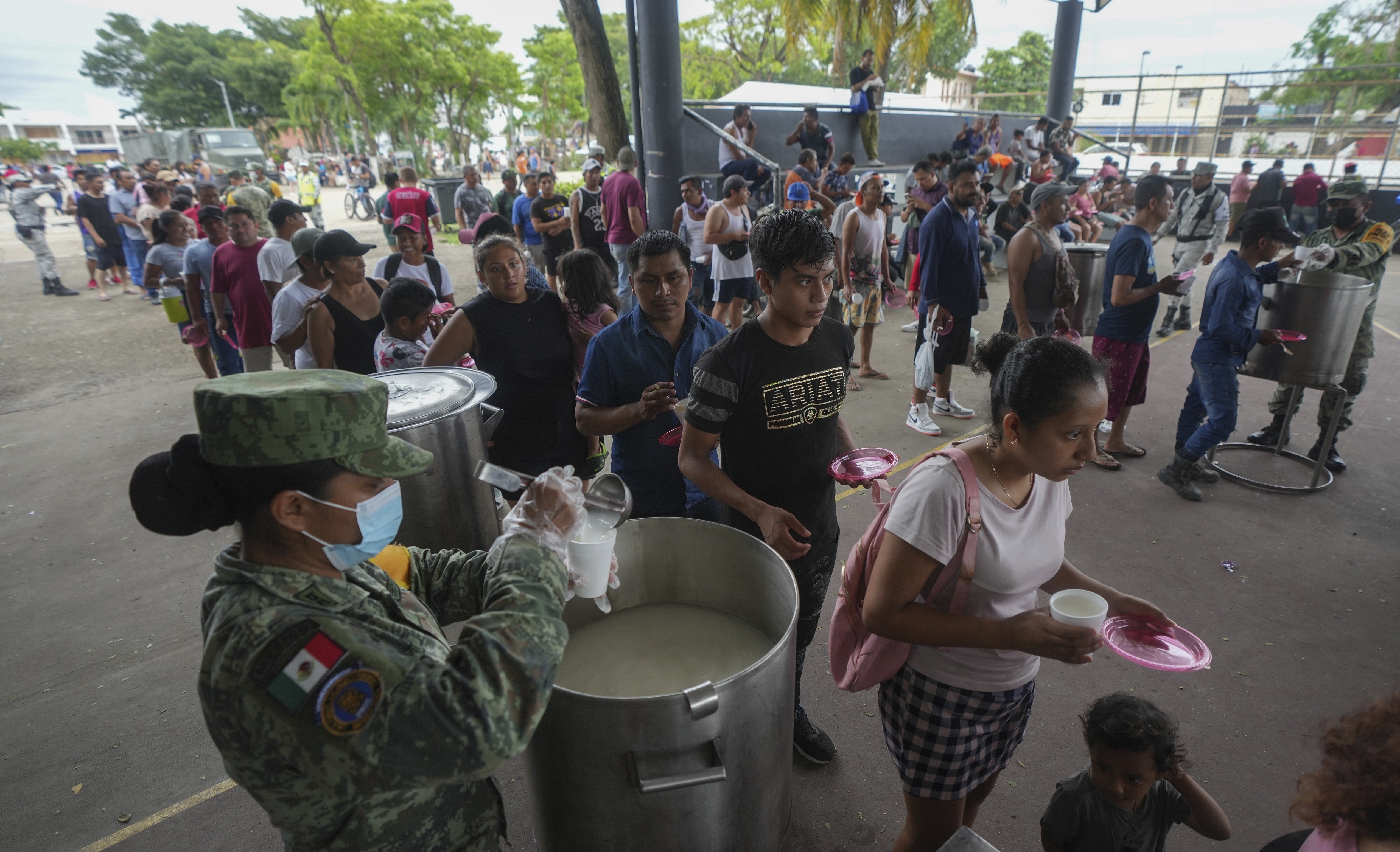 People line up to receive food at an army-provided soup kitchen for those impacted by Hurricane Beryl in Tulum, Mexico