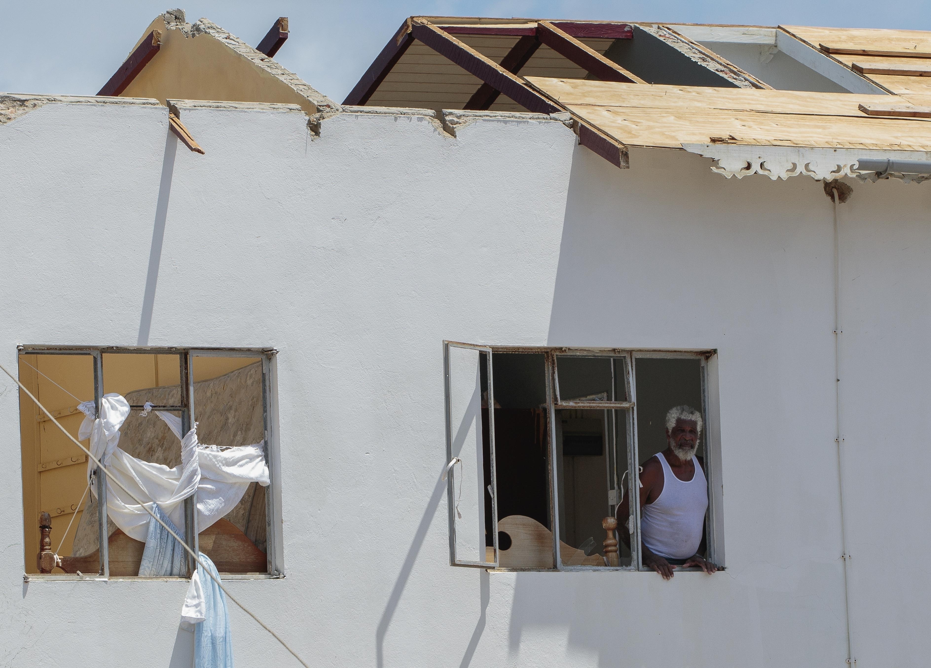 A man looks out of the window of his home, which was destroyed by Hurricane Beryl in Clifton, Union Island, St. Vincent and the Grenadines
