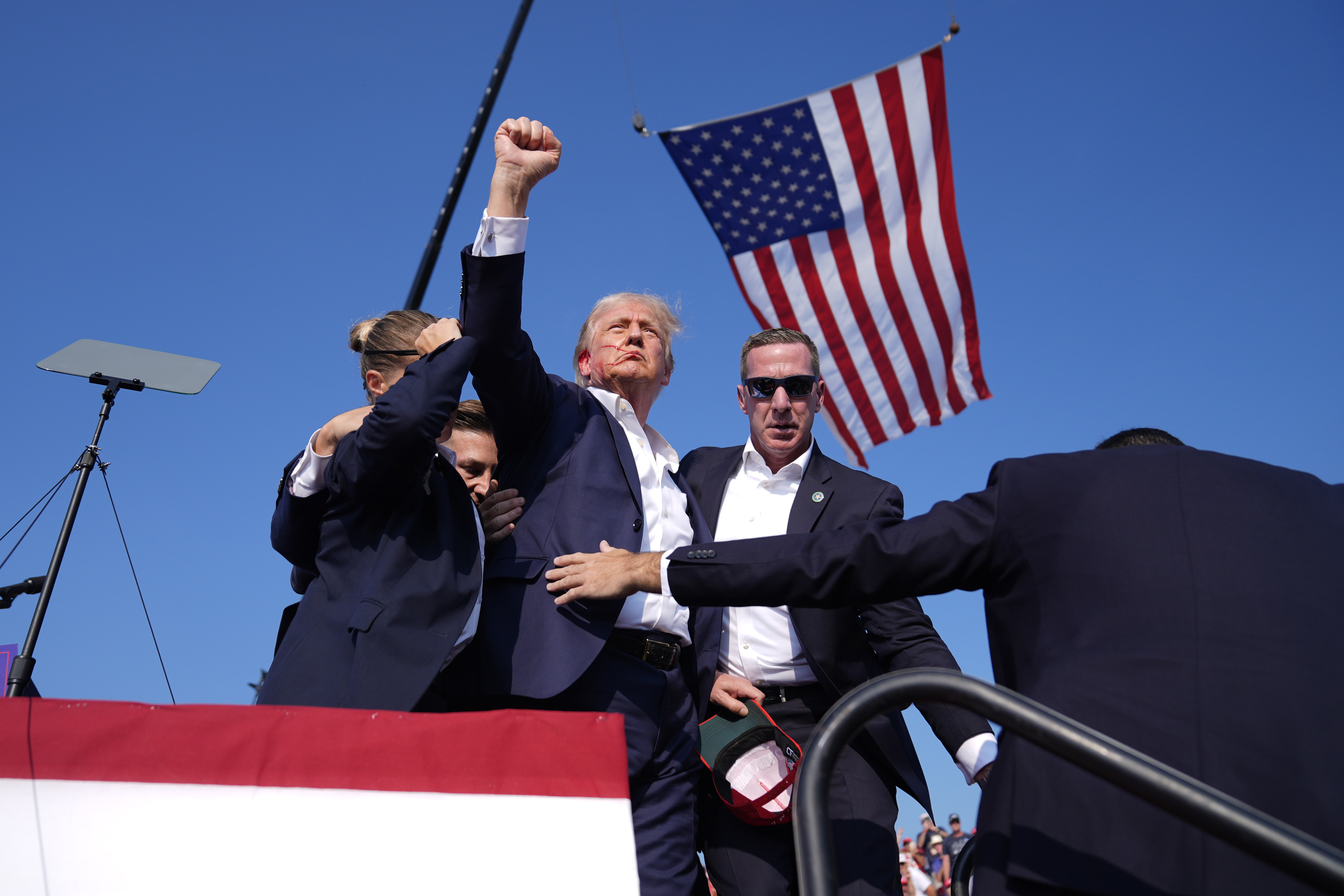 Republican presidential candidate former President Donald Trump gestures as he is surrounded by U.S. Secret Service agents as he leaves the stage at a campaign rally, Saturday, July 13, 2024, in Butler, Pa. (Evan Vucci/AP)