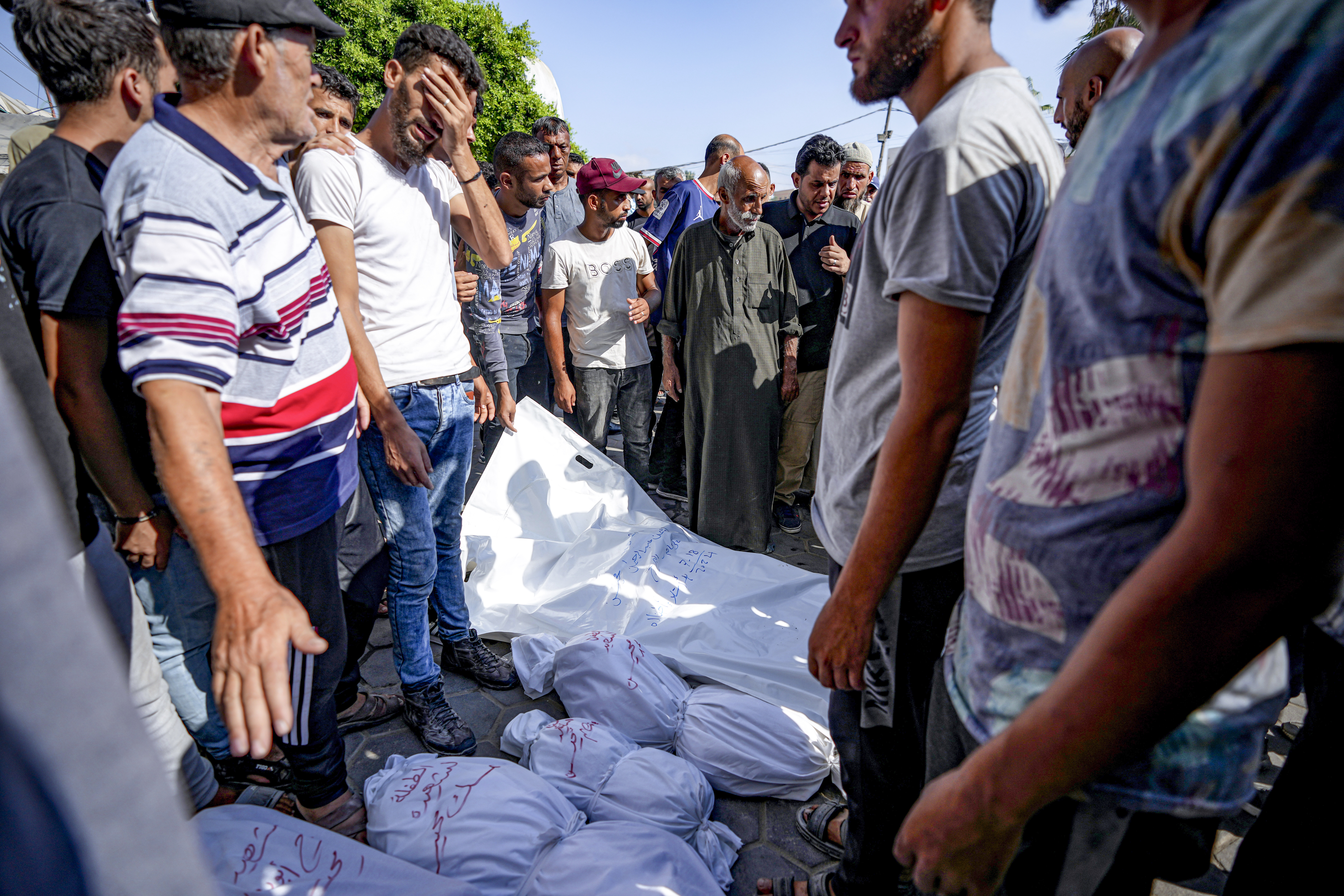 Palestinians gather near the bodies of their relatives killed in the Israeli bombardment of the Gaza Strip