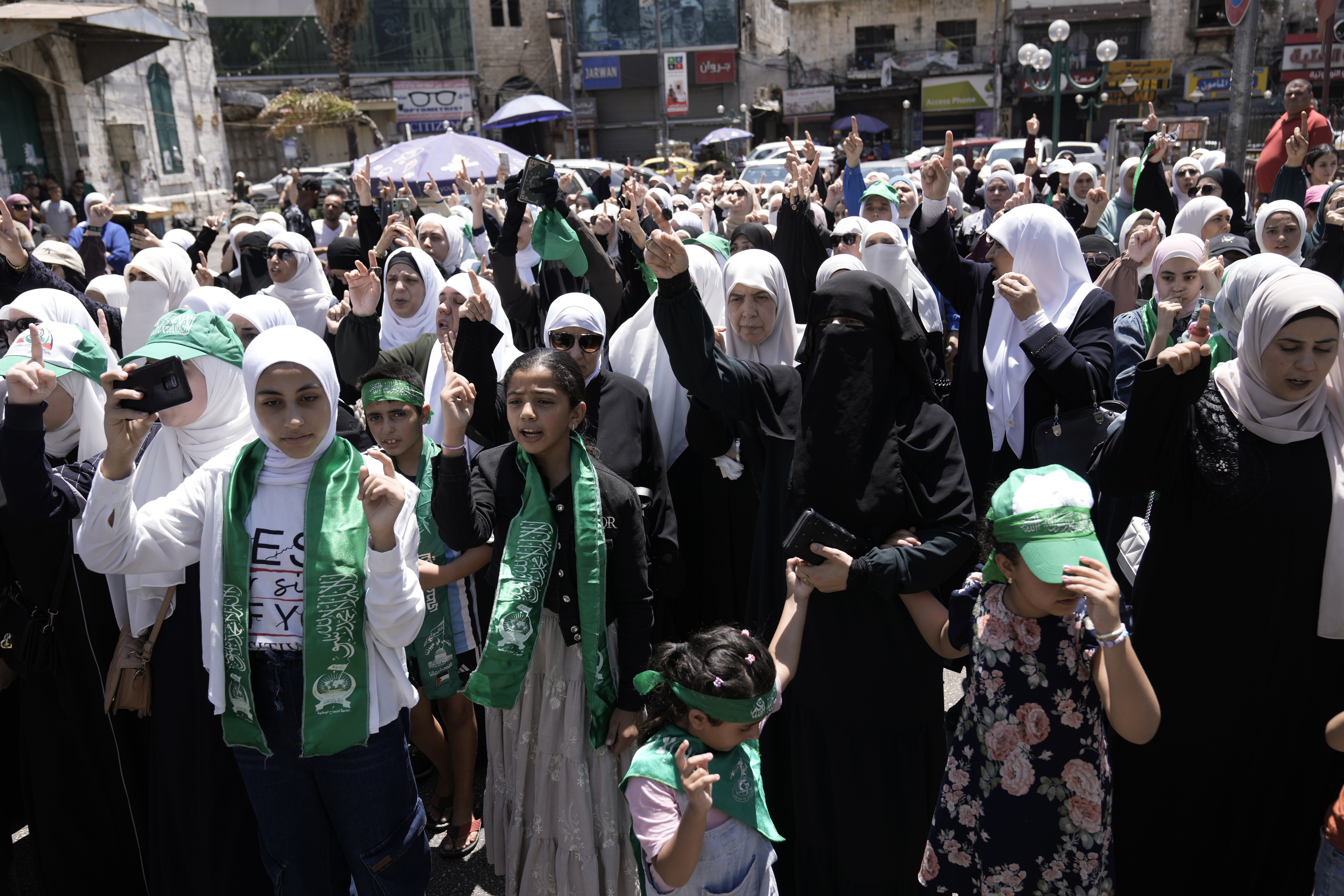 Palestinians wear Hamas militant group scarves and headbands as they protest the assassination of Hamas top leader Ismail Haniyeh, in the West Bank city of Nablus