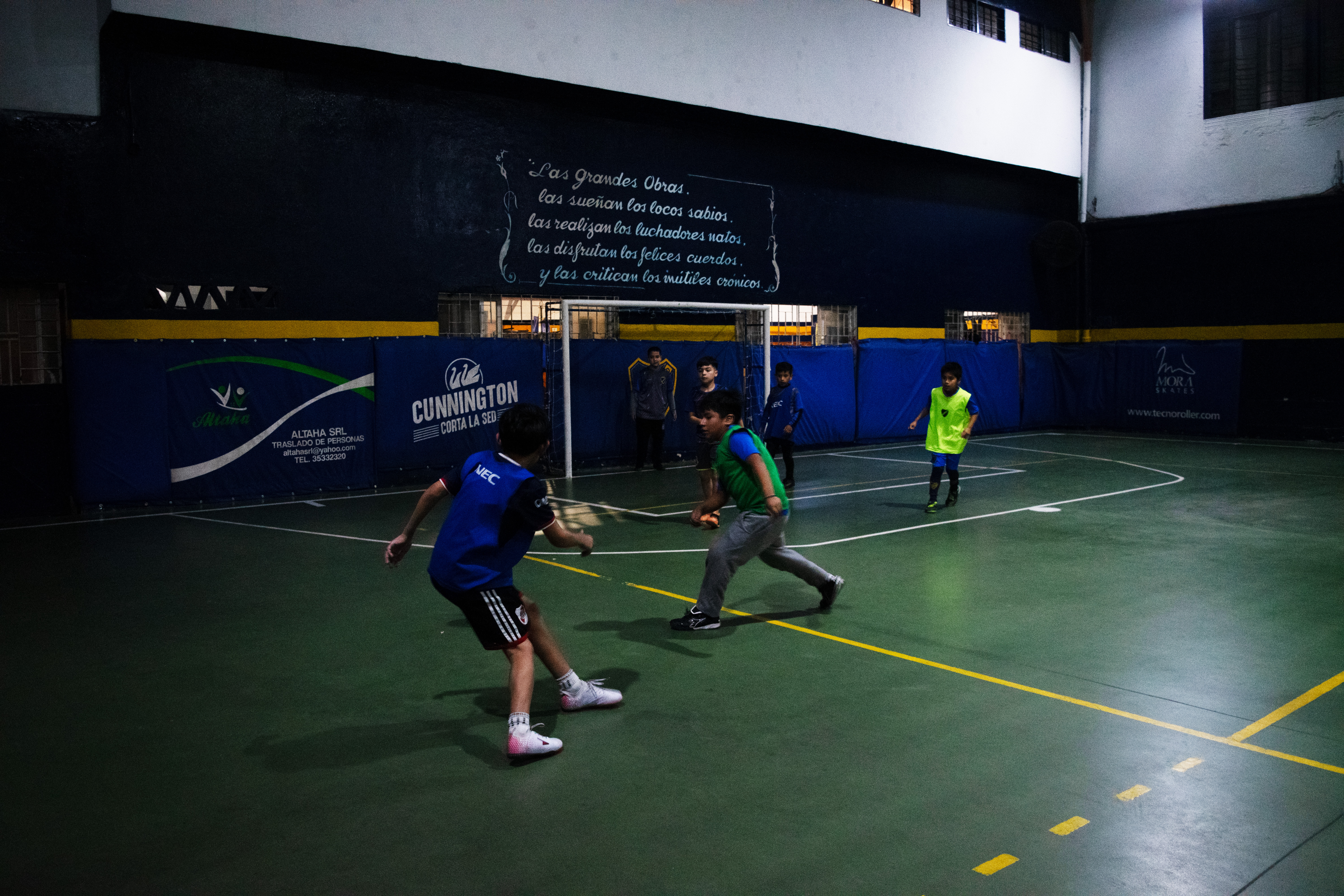 Boys in Argentina play soccer on an indoor field.