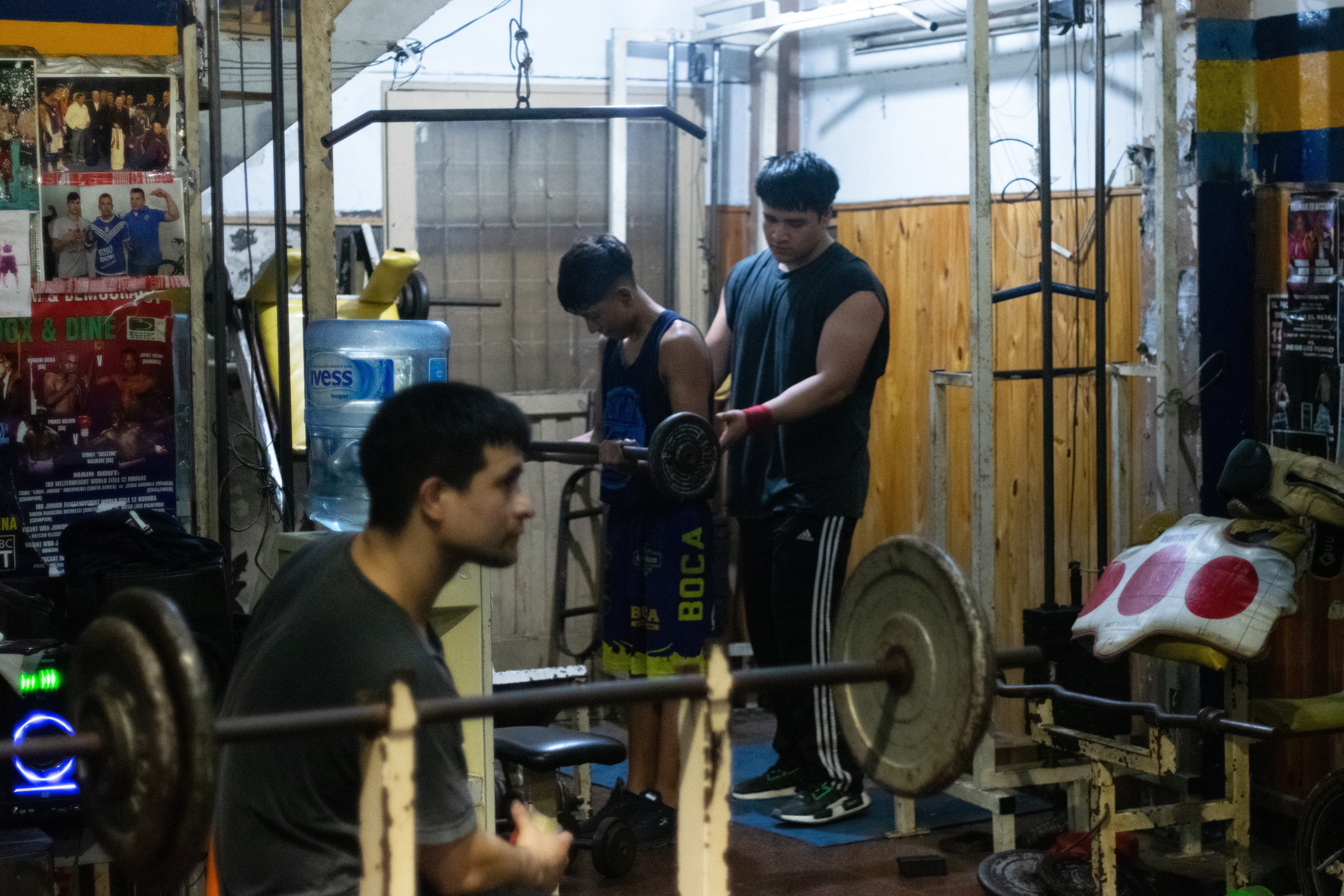 Young people use a work-out room in Argentina to lift weights.