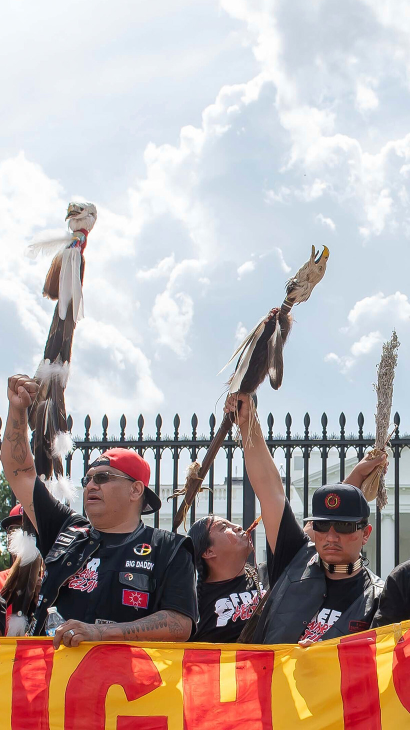 Protesters hold up a banner sign that reads: "Enough is enough! Free Leonard Peltier."