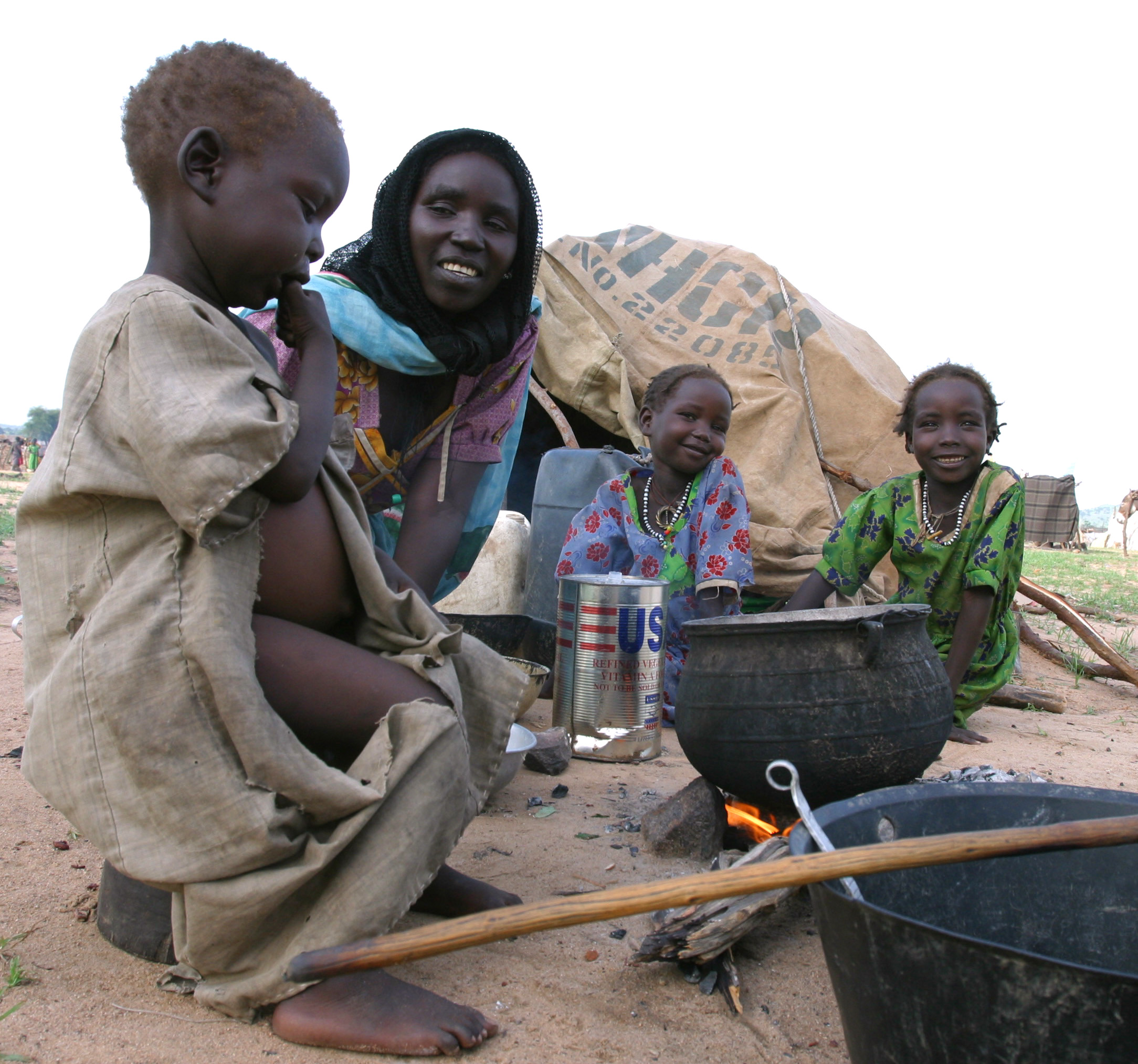 A Sudanese refugee family wait outside the Bredjing refugee camp in eastern Chad, August 24, 2004. The spontaneous camp holds an overflow of around 12,000 people who have received little help. Scores of refugees from Sudan's Darfur region are still arriving daily in eastern Chad where aid camps are overflowing and villagers say they are battling malaria and leprosy. The country's biggest camp, Bredjing, is sheltering more than 35,000 men, women and children. Aid workers fear poor sanitary conditions could trigger an outbreak of cholera and new arrivals say they are being turned away. Picture taken August 24, 2004. REUTERS/Luc Gnago LG/DBP