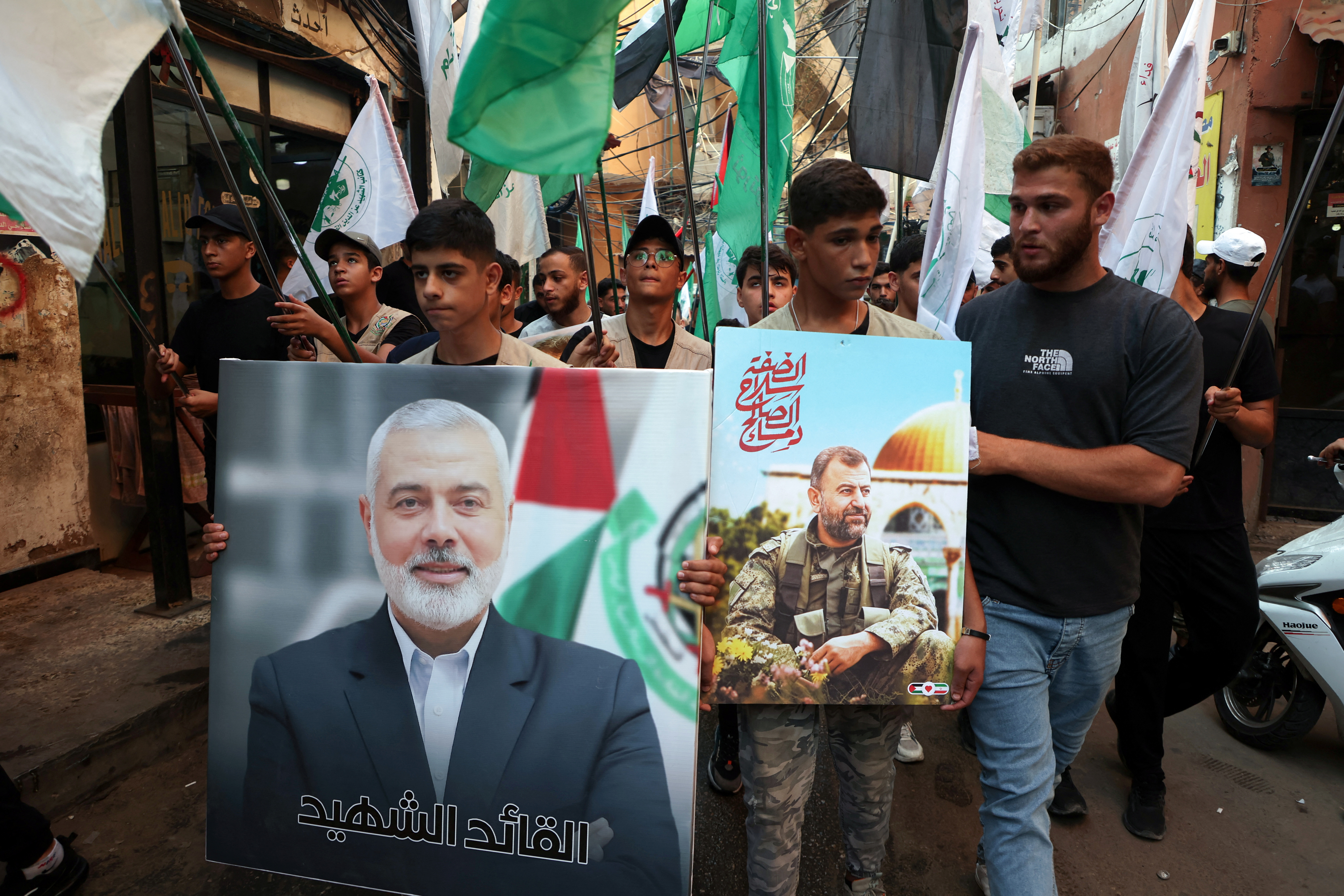 Palestinians carry pictures of Hamas' late deputy leader Saleh al-Arouri and leader Ismail Haniyeh, who was assassinated in Iran, during a march to condemn Haniyeh's killing, at Burj al-Barajneh Palestinian refugee camp in Beirut, Lebanon July 31, 2024.