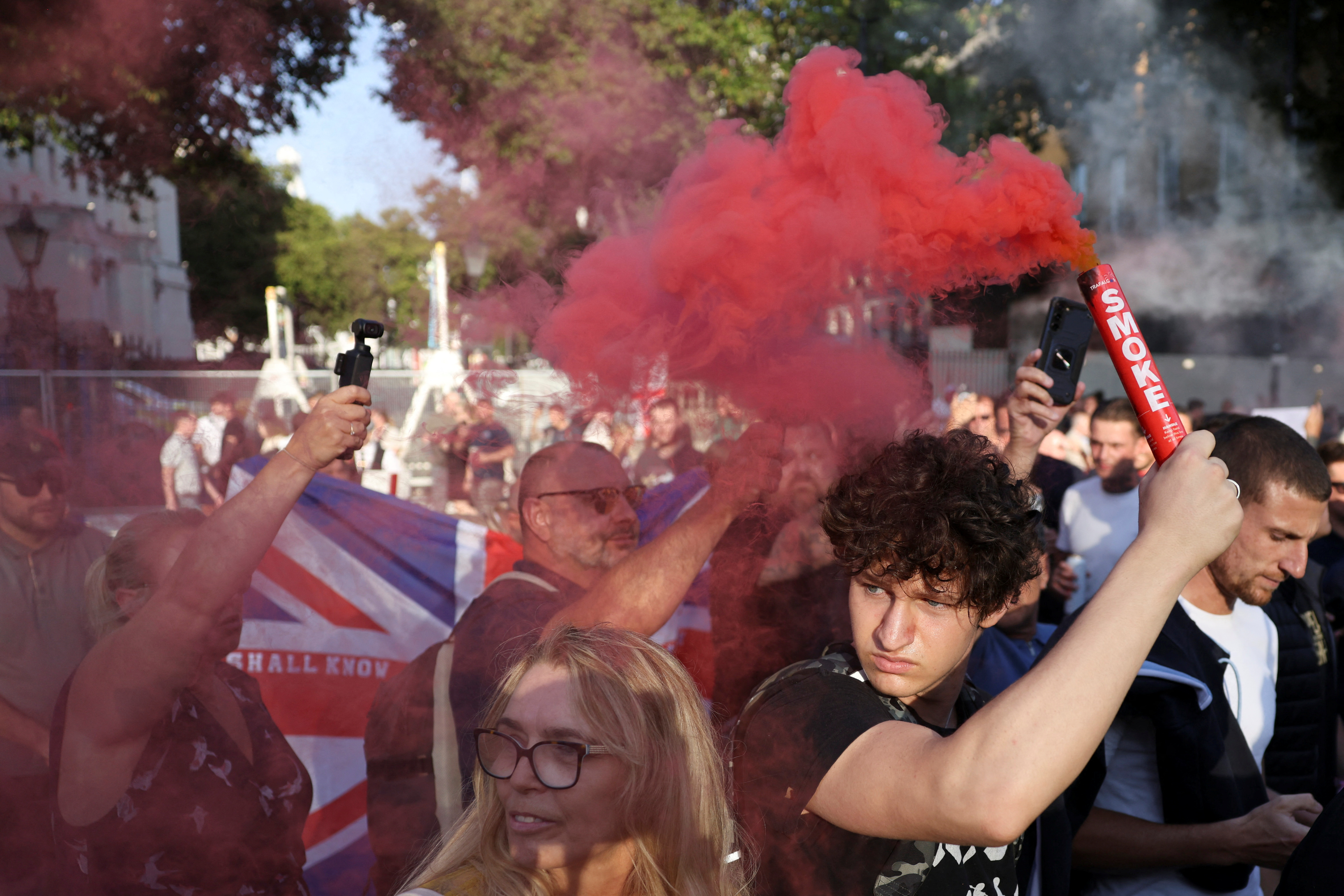 A demonstrator holds a flare during a protest against illegal immigration, in London Britain, July 31, 2024.