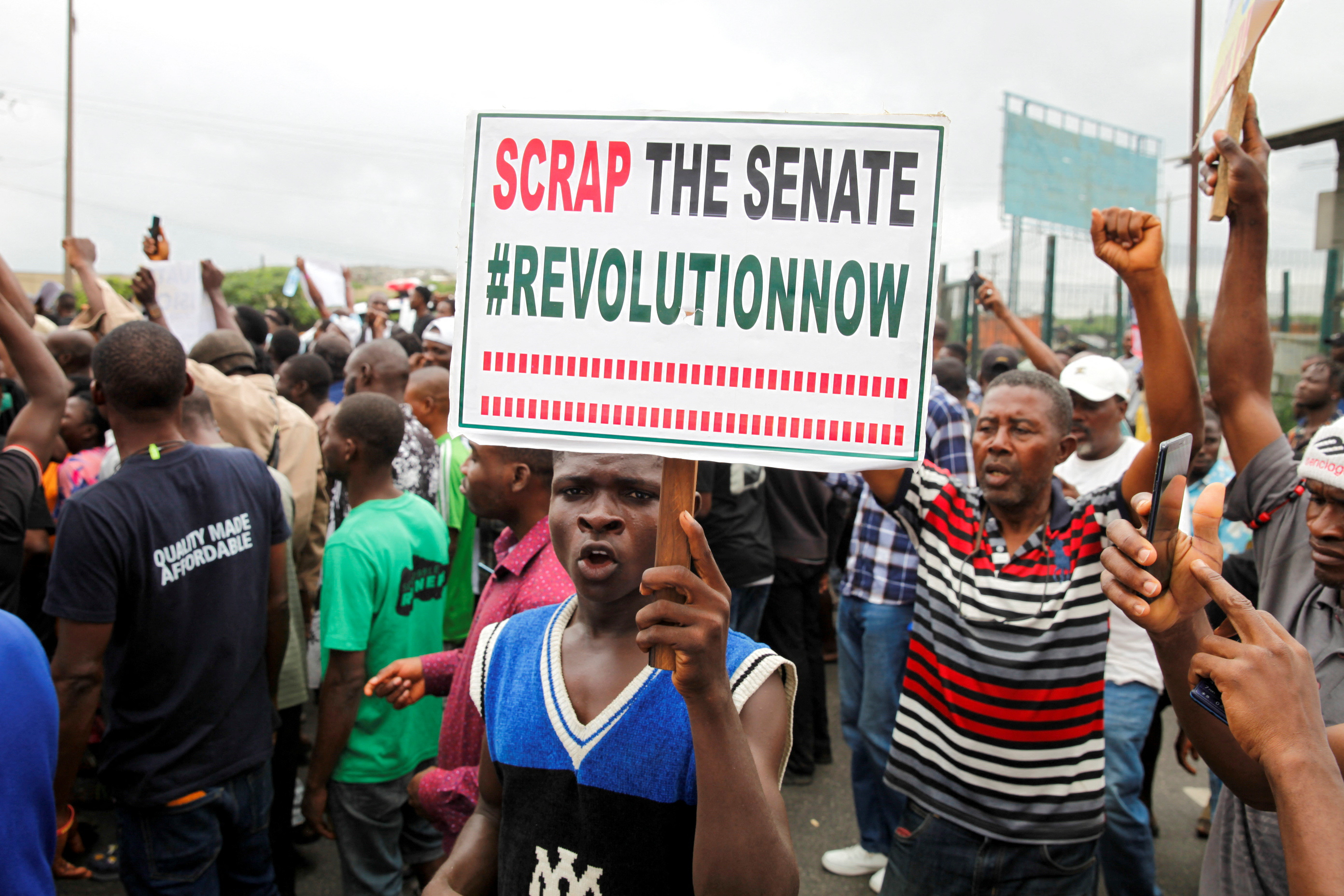 A demonstrator holds a placard, during an anti-government demonstration to protest against bad governance and economic hardship, in Lagos