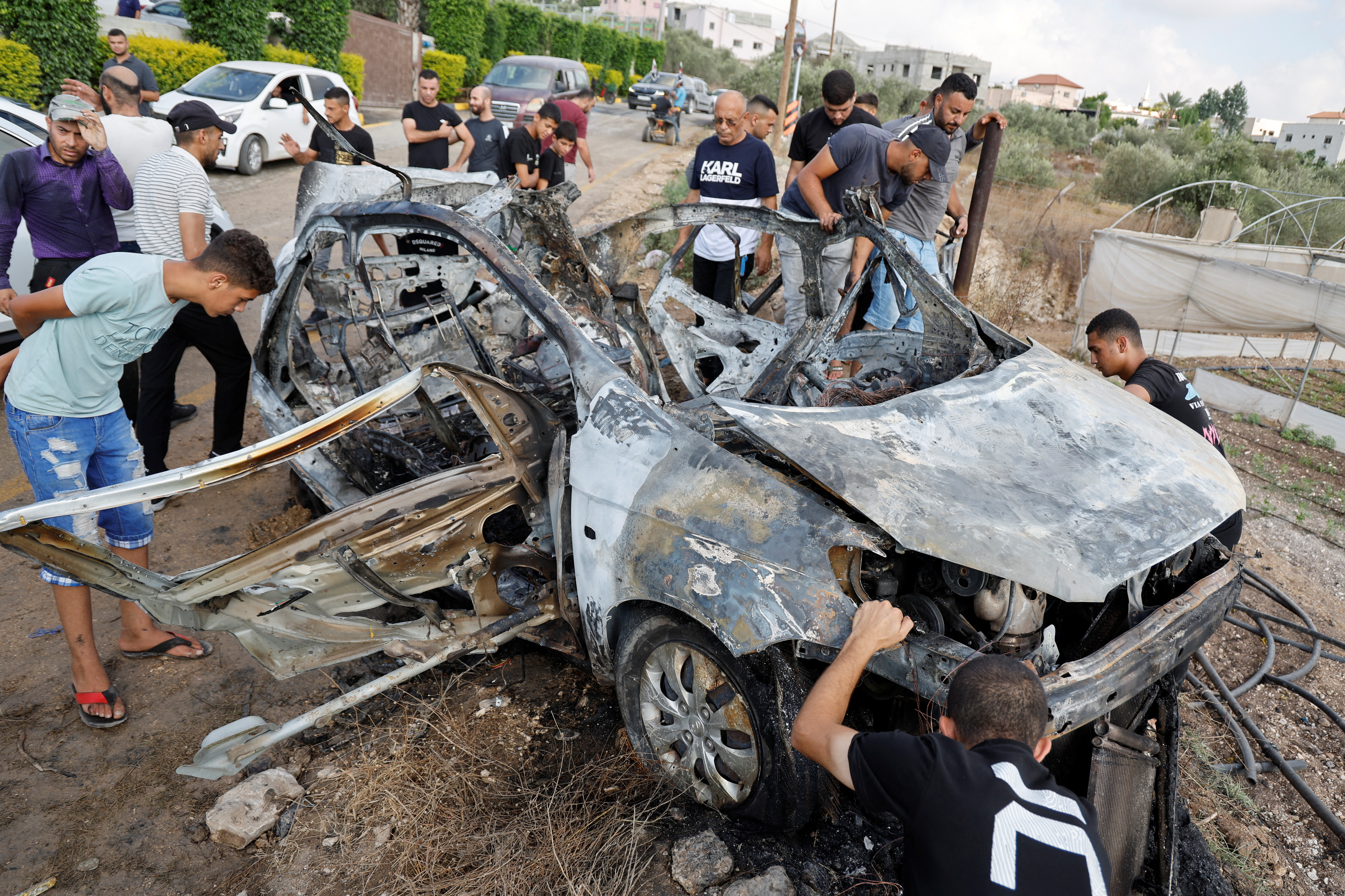 Palestinians inspect a vehicle damaged in an Israeli airstrike, in Zeita, near Tulkarm, in the Israeli-occupied West Bank, August 3, 2024. REUTERS/Raneen Sawafta
