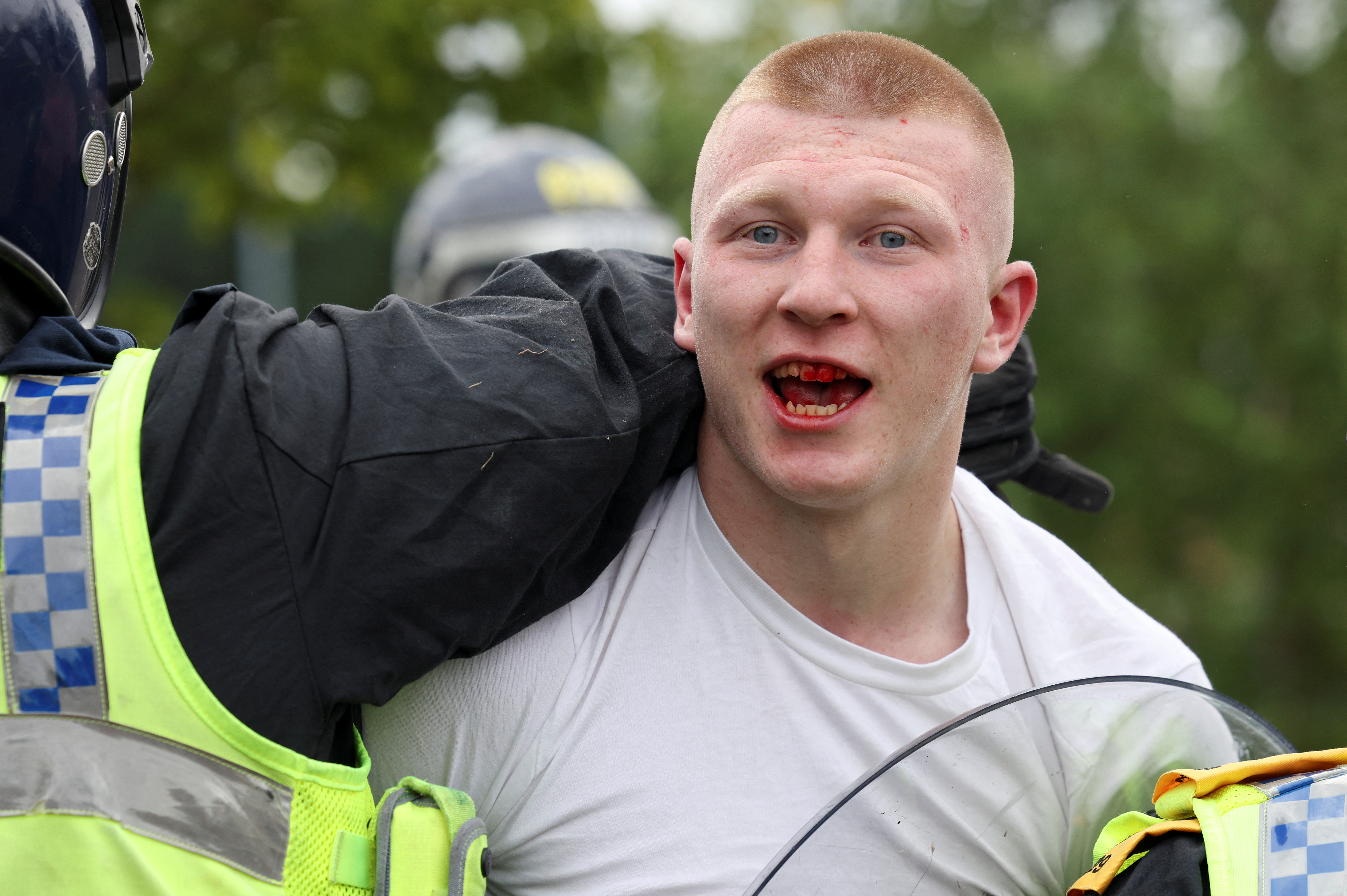 A demonstrator is detained by a police officer during an anti-immigration protest, in Rotherham, Britain, August 4, 2024. REUTERS/Hollie Adams