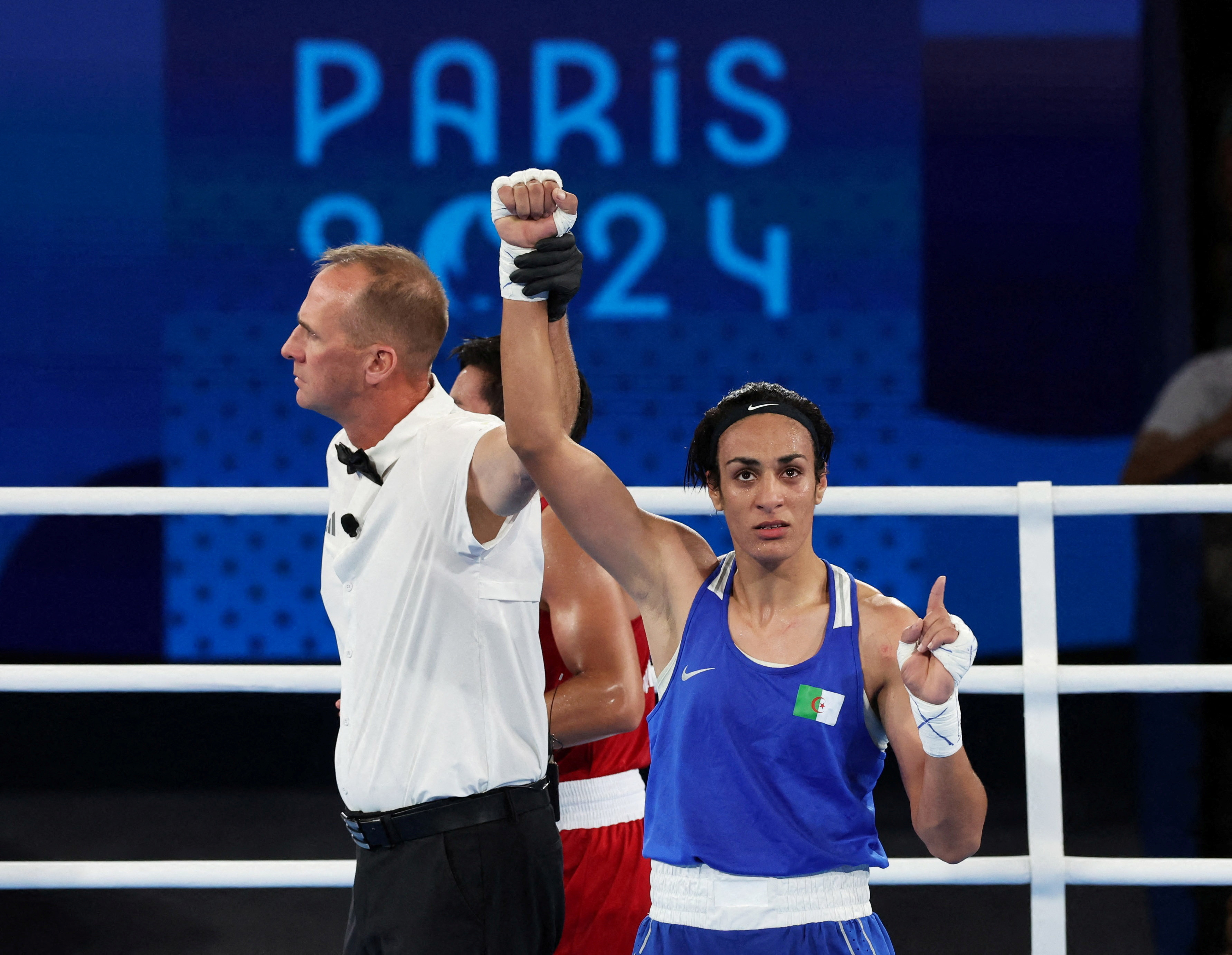 Paris 2024 Olympics - Boxing - Women's 66kg - Semifinal - Roland-Garros Stadium, Paris, France - August 06, 2024. Referee raises the arm of Imane Khelif of Algeria after winning her fight against Janjaem Suwannapheng of Thailand. REUTERS/Maye-E Wong TPX IMAGES OF THE DAY