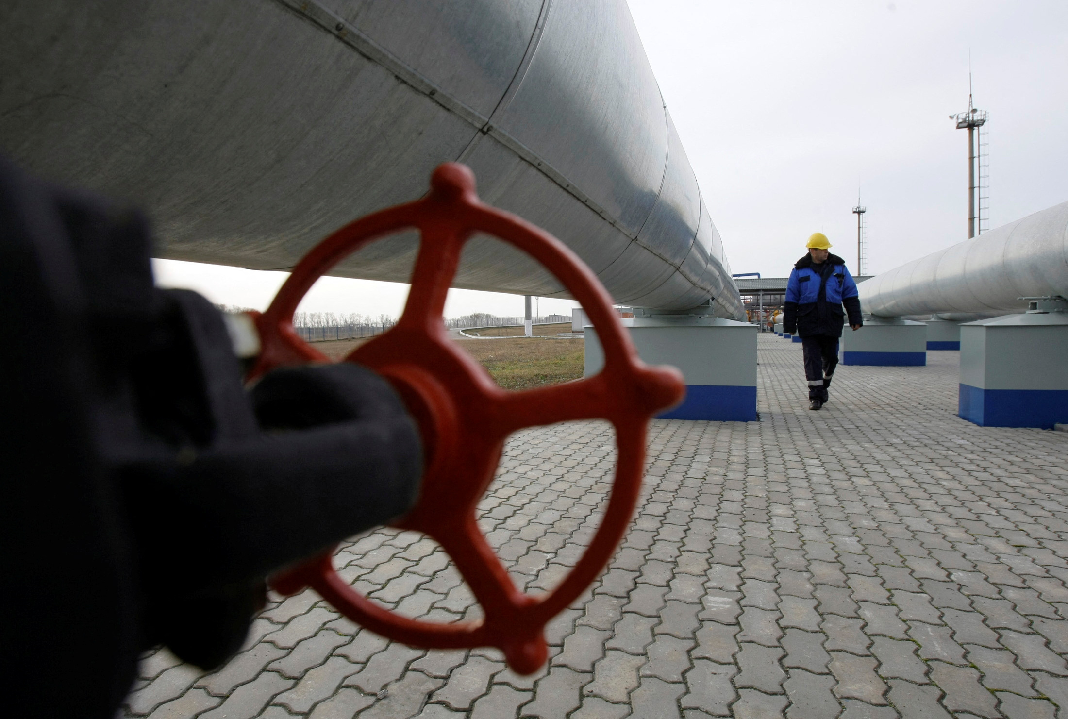 A Gazprom worker walks next to pipelines