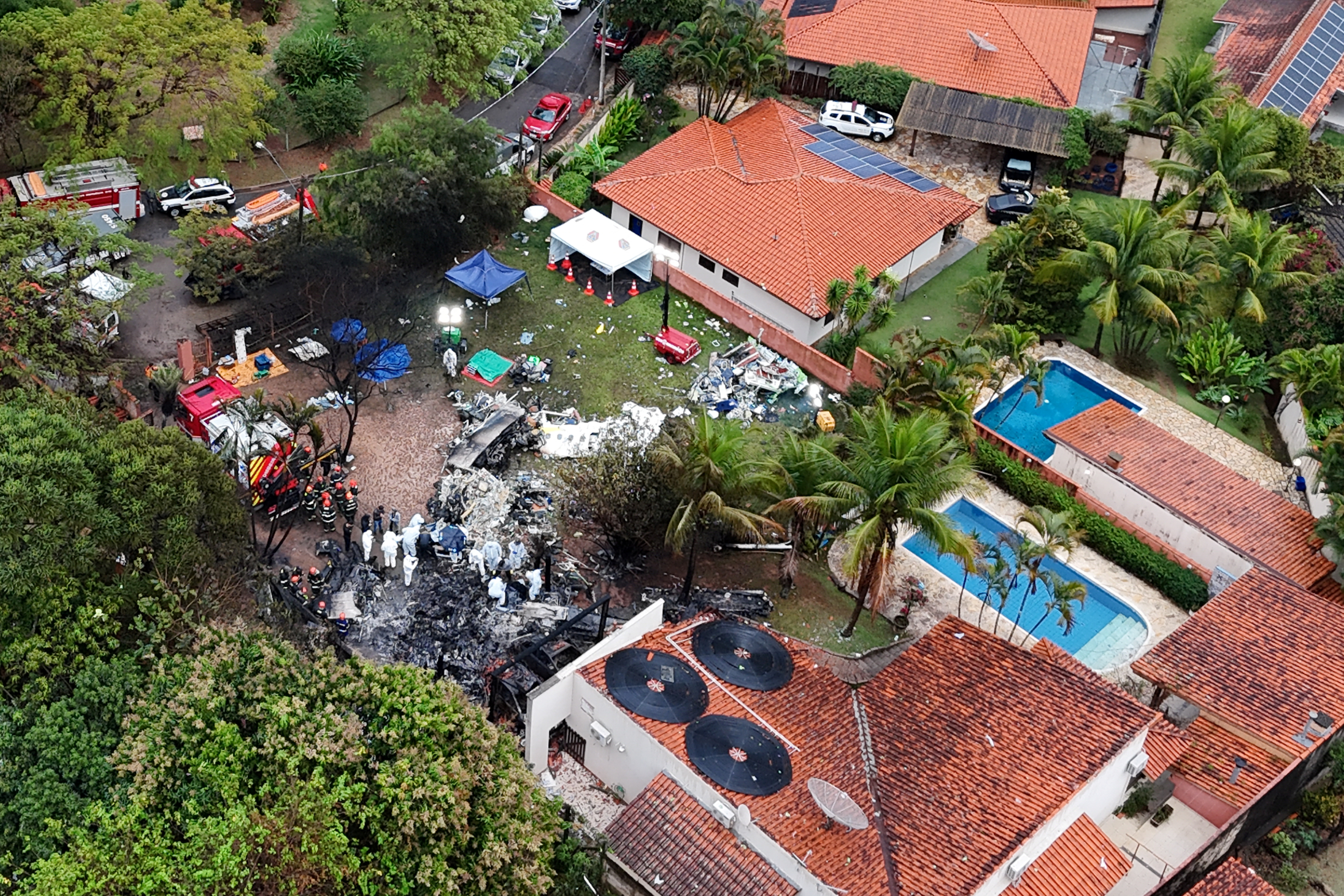 A drone view shows people working at the site of the plane crash in Vinhedo, August 10