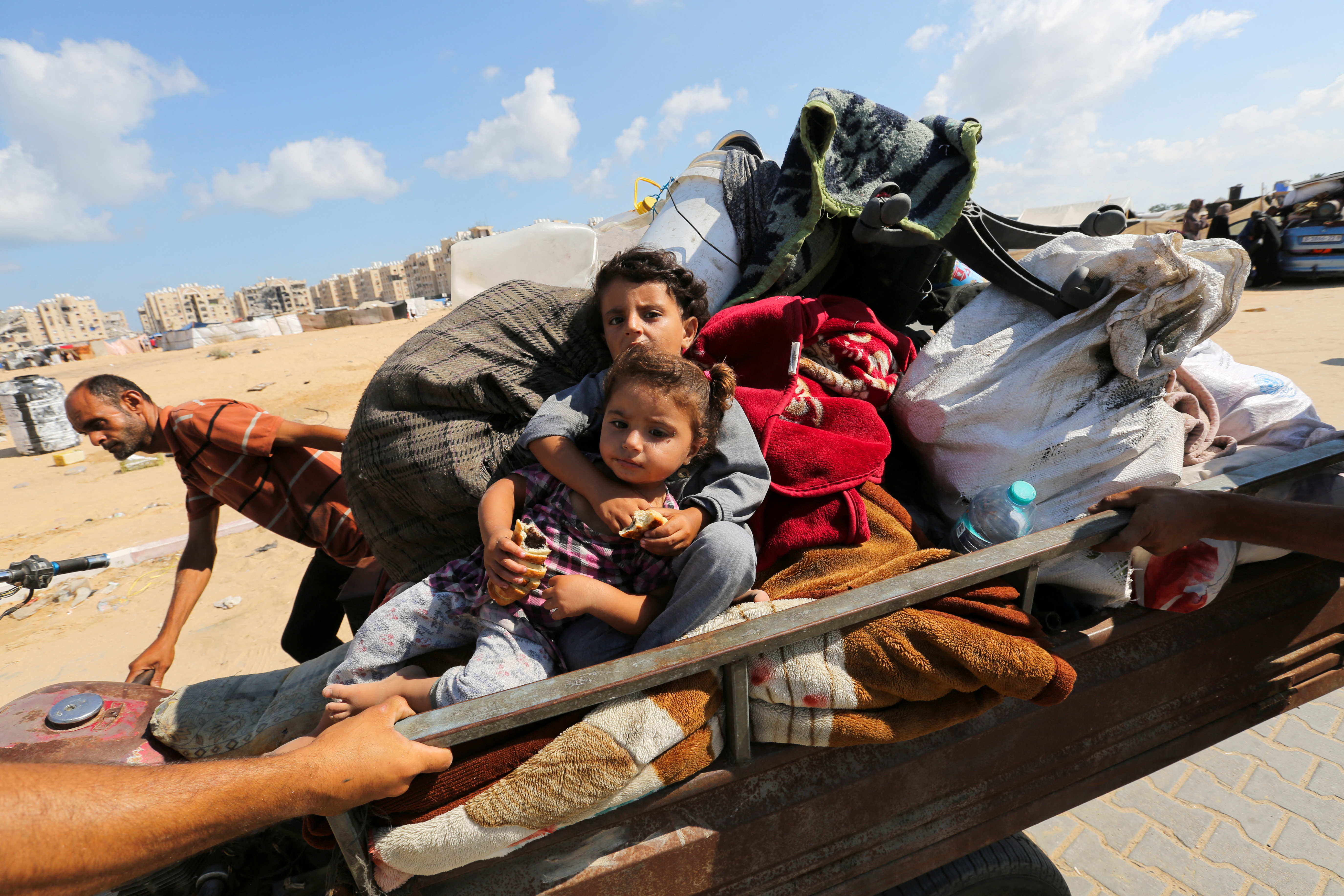 Displaced Palestinians make their way as they flee Hamad City following an Israeli evacuation order, in Khan Younis in the southern Gaza Strip