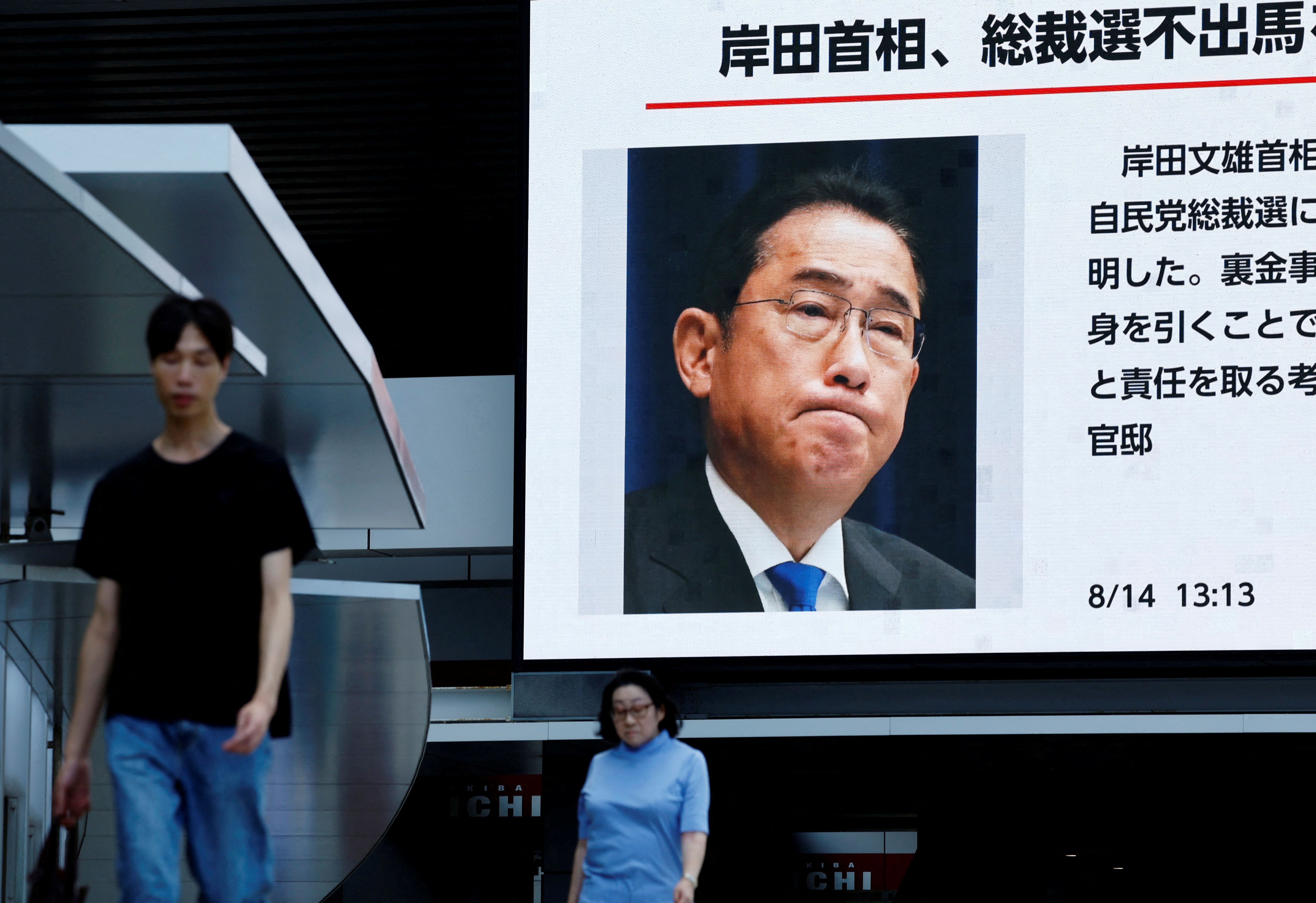People walk past a large screen showing the news about Japanese Prime Minister Fumio Kishida's announced resignation next month in Tokyo, Japan August 14, 2024. REUTERS/Kim Kyung-Hoon TPX IMAGES OF THE DAY