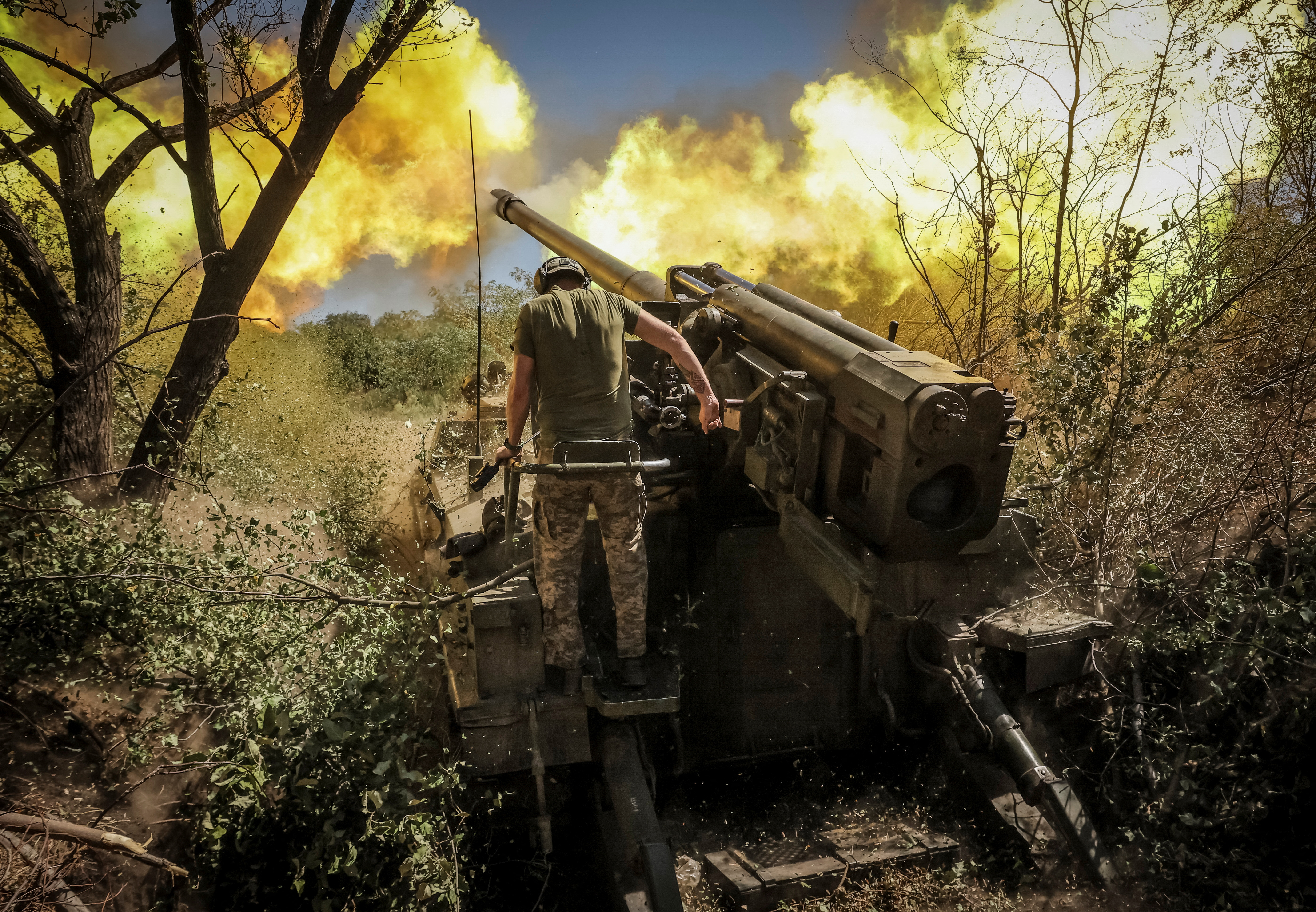 A serviceman of 24th Mechanized brigade named after King Danylo of the Ukrainian Armed Forces fires a 2s5 "Hyacinth-S" self-propelled howitzer towards Russian troops at a front line