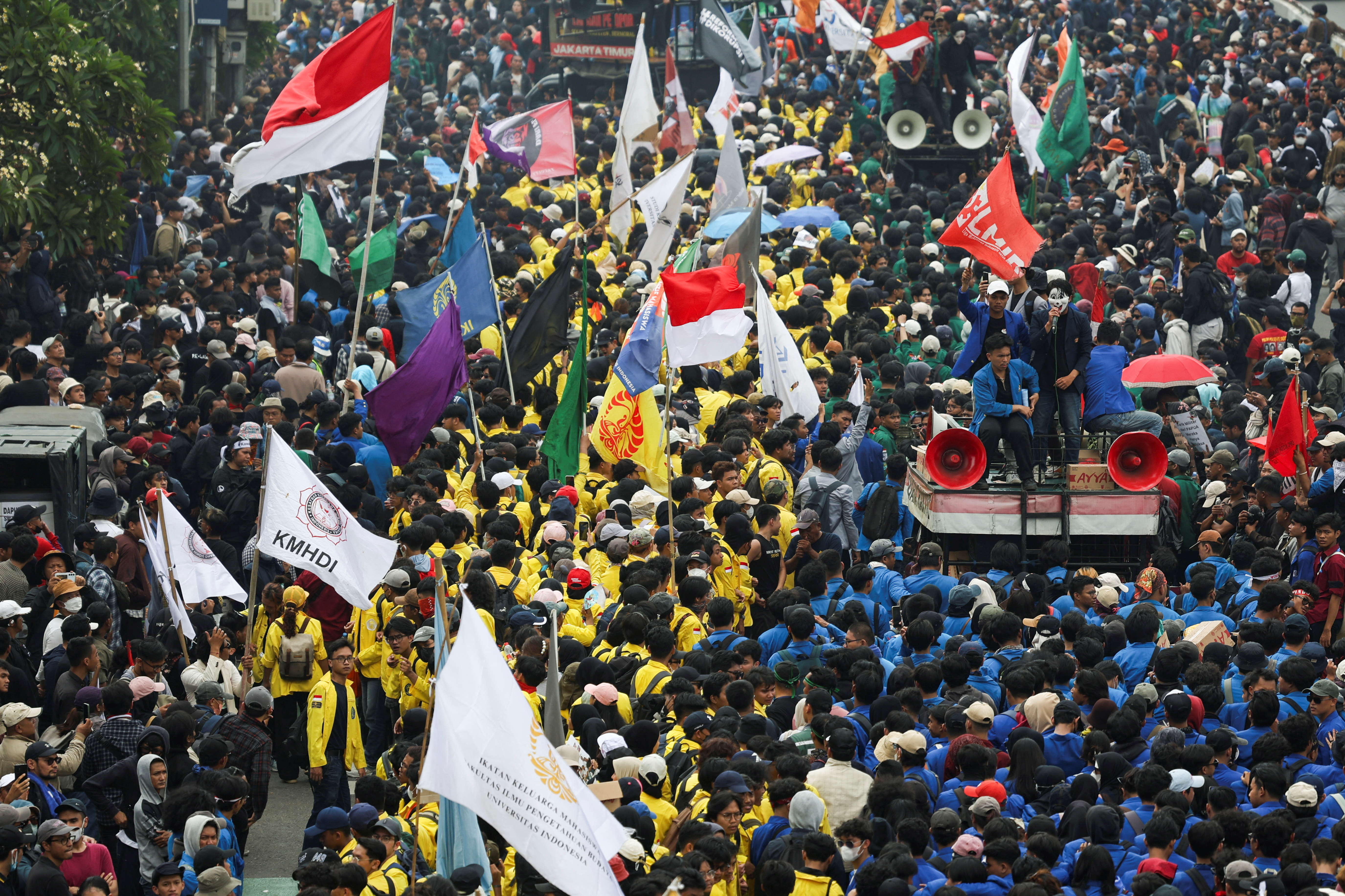 People attend a protest outside the Indonesian Parliament against the revisions to the country's election law