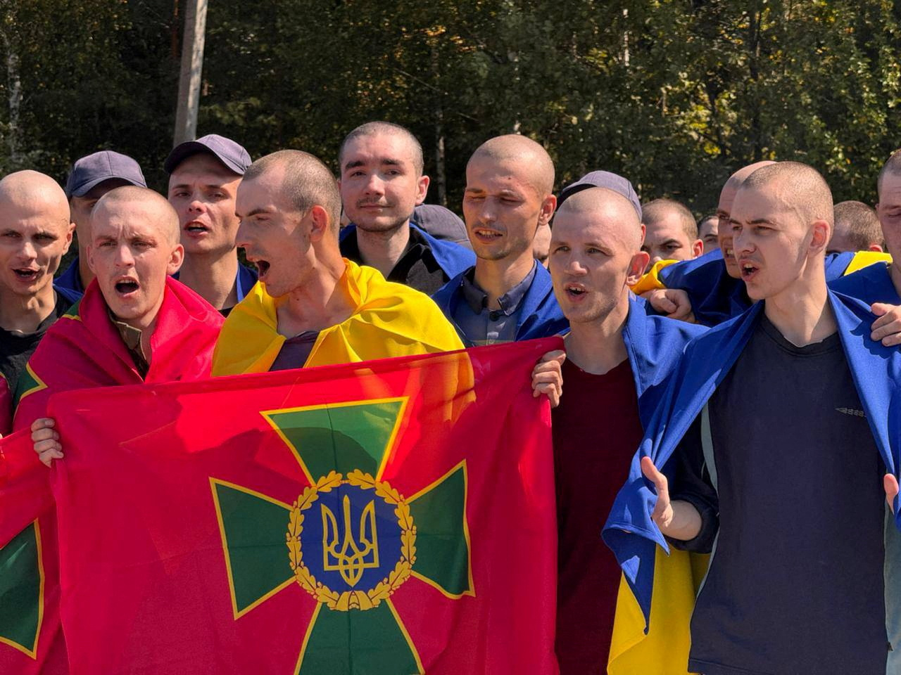 Ukrainian prisoners of war (POWs) react after a swap, amid Russia's attack on Ukraine, at an unknown location in Ukraine, in this handout picture