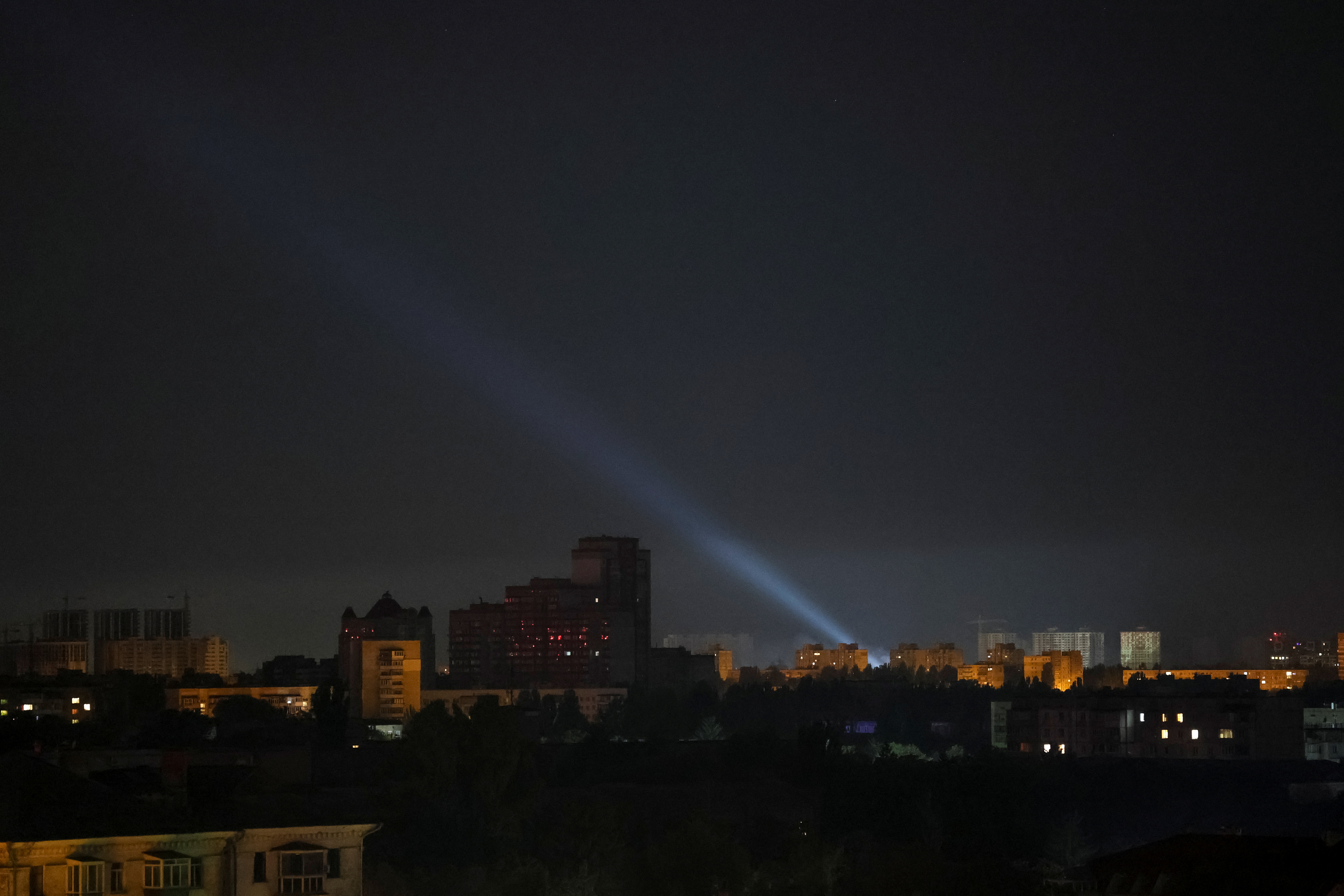 Ukrainian service personnel use a searchlight as they search for drones in the sky