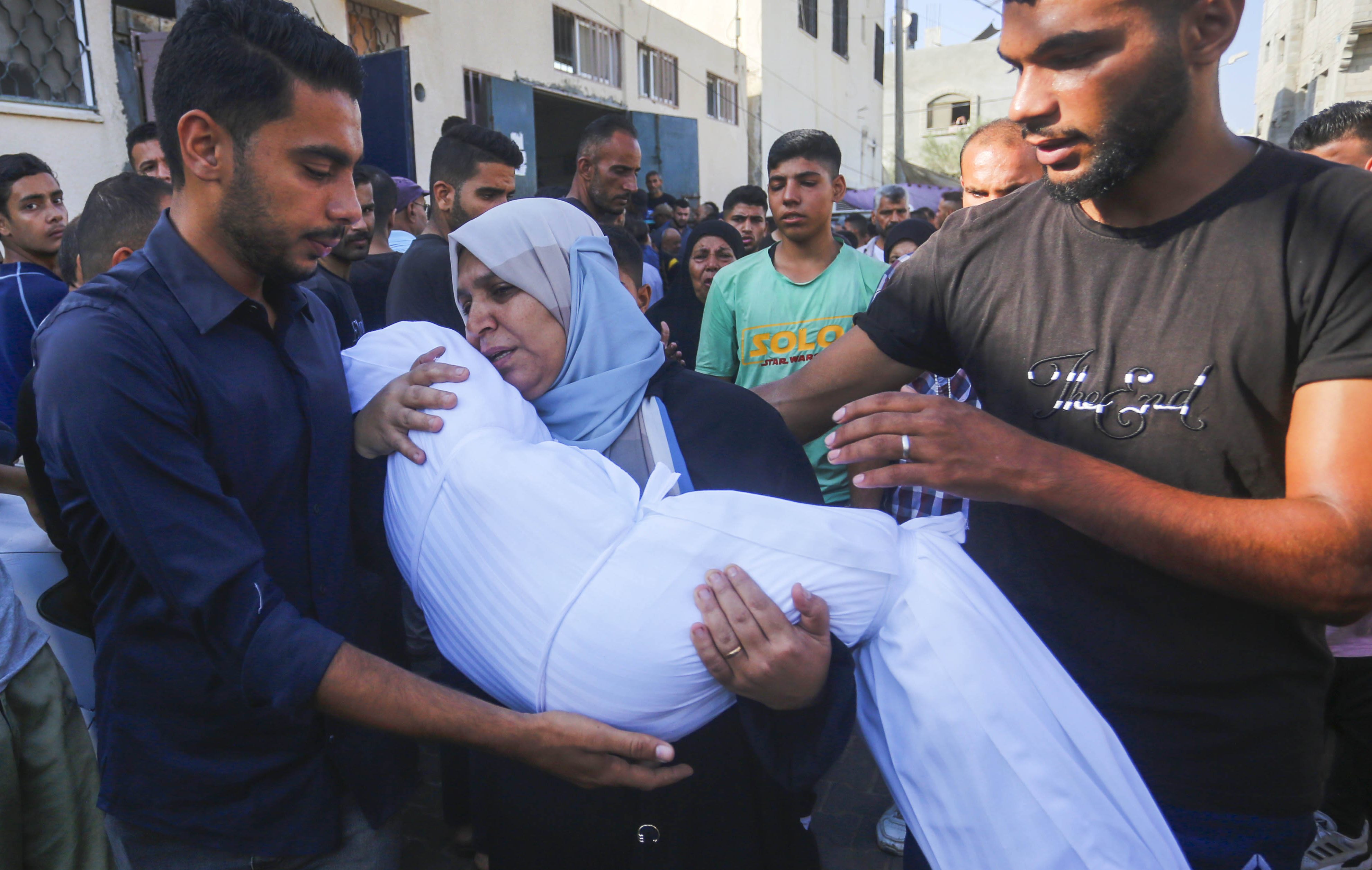 Relatives of Palestinians, who lost their lives in an Israeli army attack on Al-Maghazi refugee camp, mourn as the bodies are brought to Al-Aqsa Martyrs Hospital