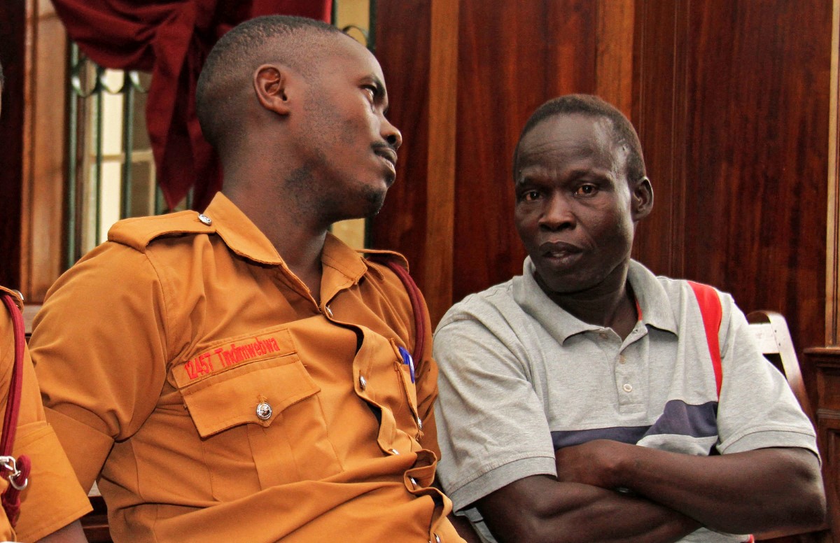 Suspected LRA (Lords Resistance Army) member Thomas Kwoyelo (R) is pictured during a pre-trial session at the High Court in Kampala on Februay 1, 2017. Kwoyelo is indicted on 93 counts including murder, rape, defilement, destruction of crops and property, recruitment of children as soldiers and other crimes against humanity which were allegedly committed as one of the Lord Resistance Army (LRA) commanders during the 20 years of political insurgency in northern Uganda. (Photo by GAEL GRILHOT / AFP)
