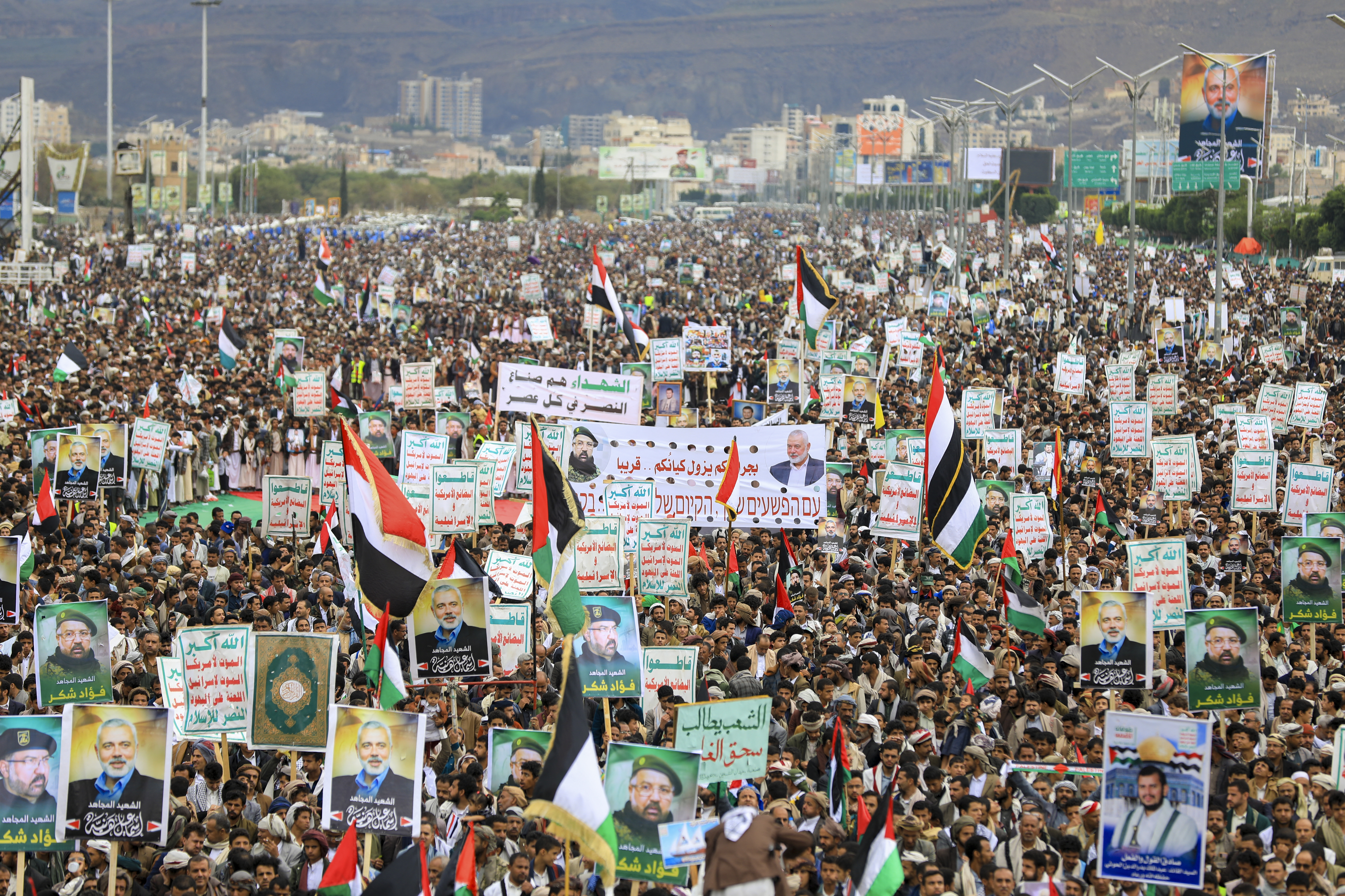 Yemenis wave flags and lift placards of Hezbollah senior commander Fuad Shukr, who was killed in an Israeli strike, and slain Hamas chief Ismail Haniyeh, during a rally in the Huthi-controlled capital Sanaa on August 2, 2024, denouncing their killing, amid the ongoing conflict in the Gaza Strip between Israel and the Palestinian Hamas movement. - Haniyeh, the Palestinian armed group's political chief, who was killed on July 31 in the Iranian capital Tehran, played a key role in mediated talks aimed at ending nearly 10 months of war between Hamas and Israel in Gaza. (Photo by Abdallah ADEL / AFP)
