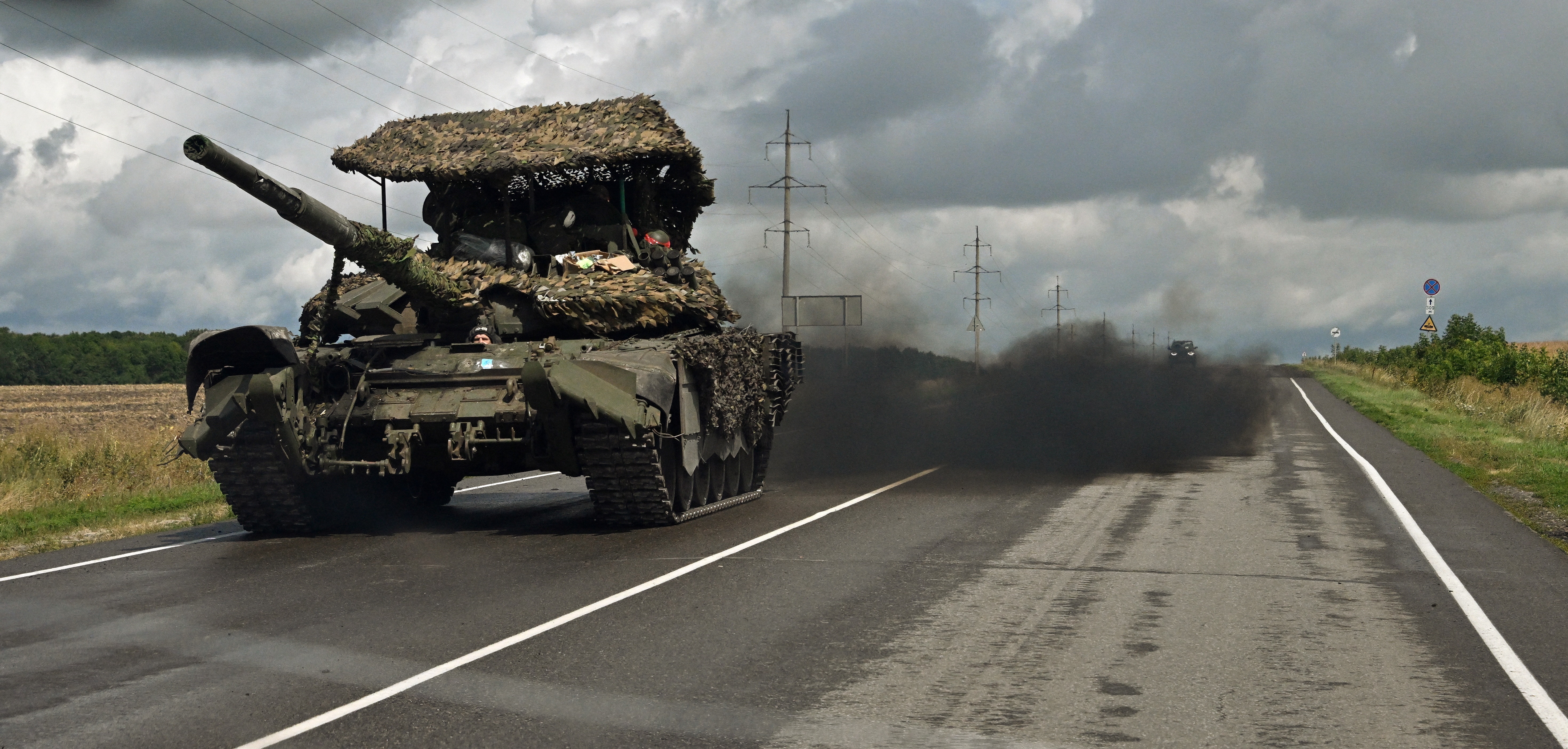A Russian battle tank on the road near Sudzha. It is belching lots of black smoke