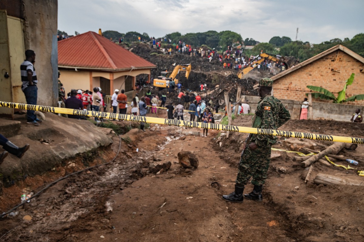 A crime scene police officer seals off the area following the collapse of a landfill in Kampala on August 10, 2024. - Eight people including two children were killed when mountains of garbage collapsed at a landfill in the Ugandan capital Kampala on August 10, the city authority said. (Photo by BADRU KATUMBA / AFP)