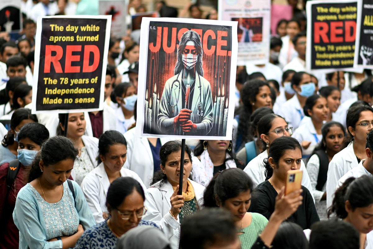 Medical professionals hold posters amid nationwide strike by doctors to condemn the rape and murder of a young medic from Kolkata, at a hospital in Bengaluru on August 17, 2024. - Indian doctors held a nationwide strike on August 17, escalating protests after the "barbaric" rape and murder of their colleague that has channelled outrage at the chronic issue of violence against women. (Photo by Idrees MOHAMMED / AFP)
