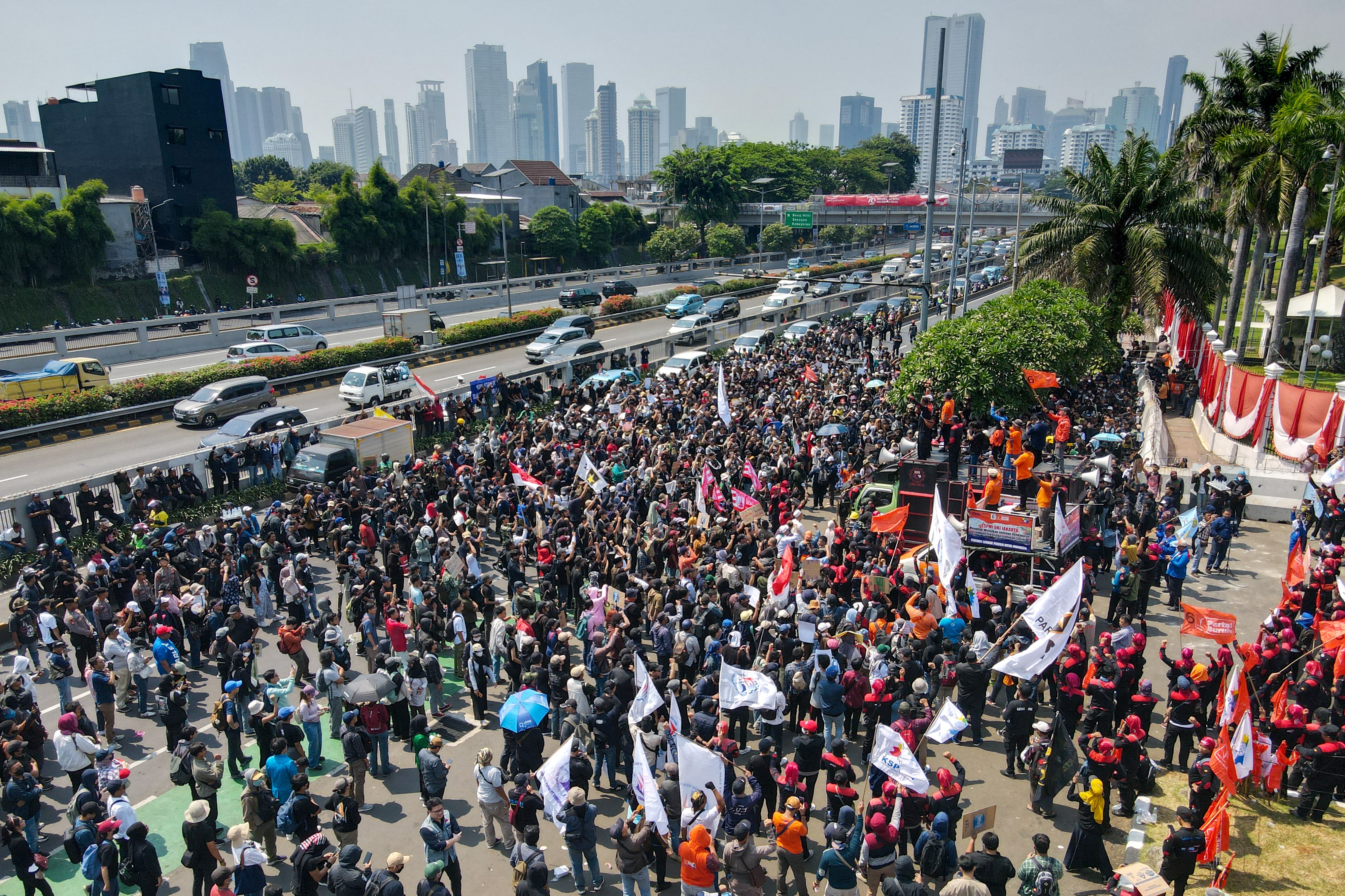 People attend a protest outside the Indonesian Parliament against the revisions to the country's election law