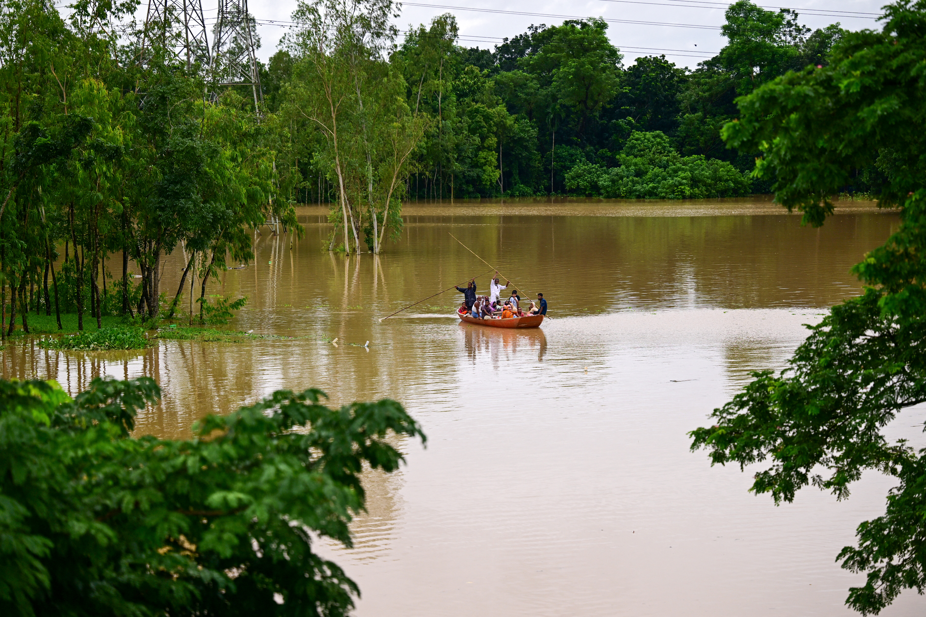 People wade through flood waters in Feni