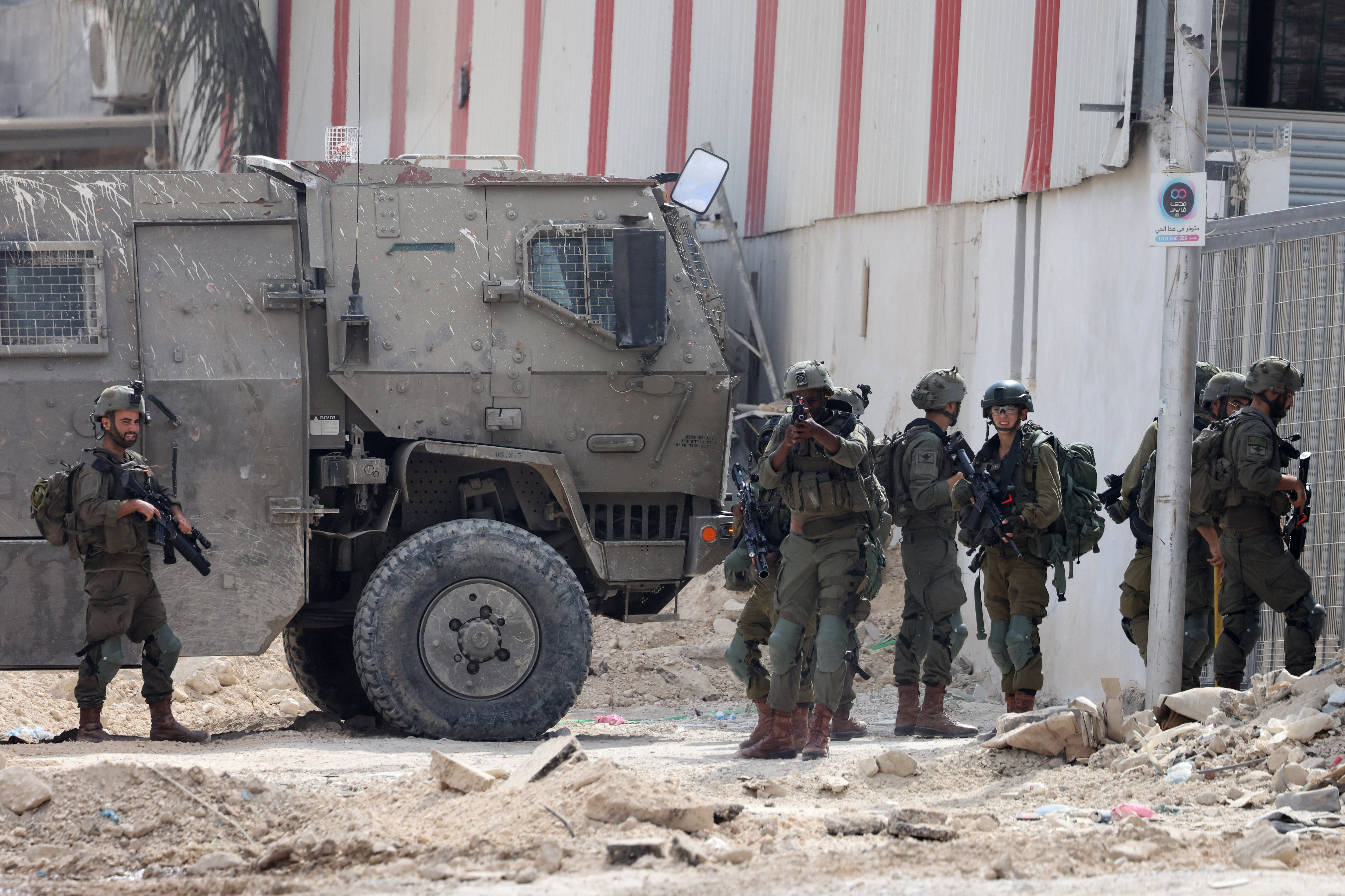 Israeli soldiers operate during a raid in the Nur Shams camp for Palestinian refugees near the city of Tulkarem in the Israeli-occupied West Bank on August 28, 2024. - At least 10 Palestinians were killed in Israeli raids and strikes in several towns in the north of the occupied West Bank, a spokesman for the Red Crescent said on August 28. The operation comes two days after Israel said it carried out an air strike on the West Bank that the Palestinian Authority reported killed five people. (Photo by JAAFAR ASHTIYEH / AFP)